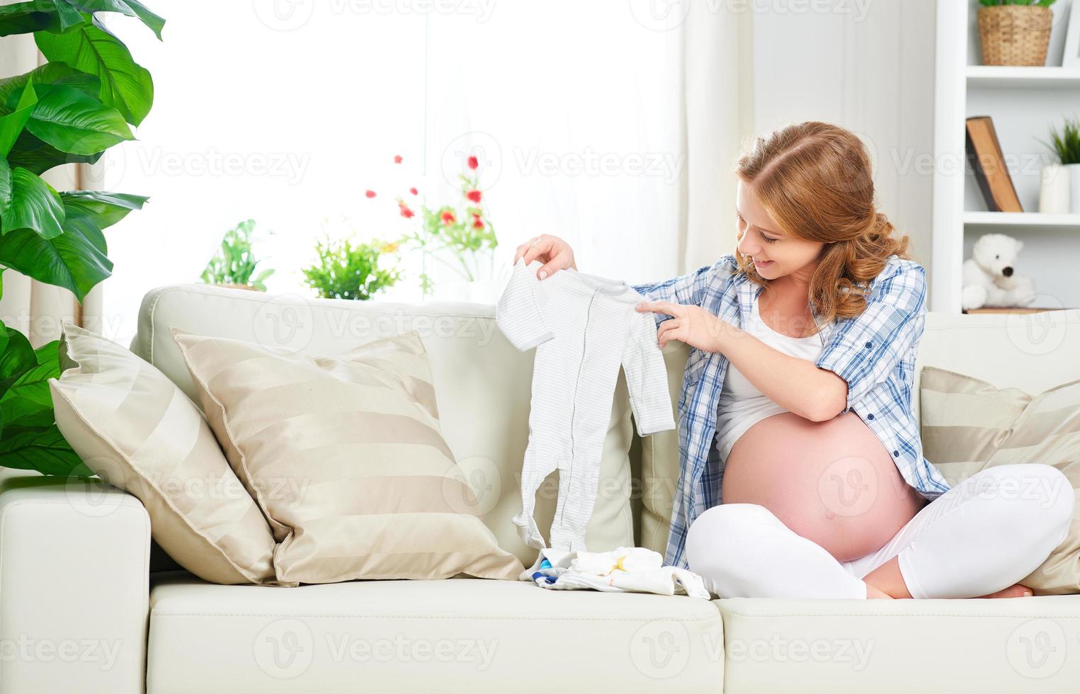 mulher grávida gestante prepara itens de vestuário para newb foto