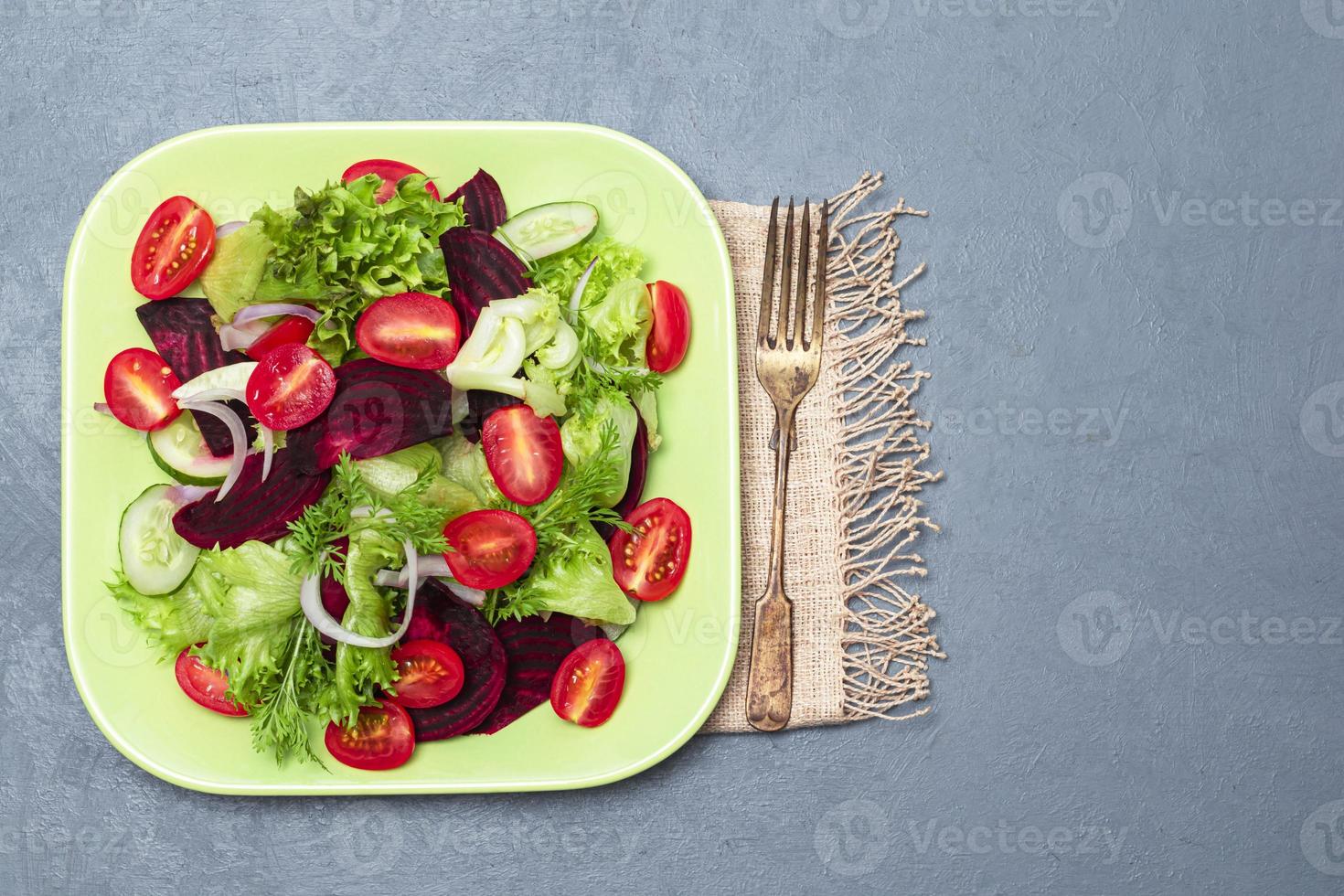 salada de beterraba saudável em tigela verde sobre fundo cinza de madeira. foto