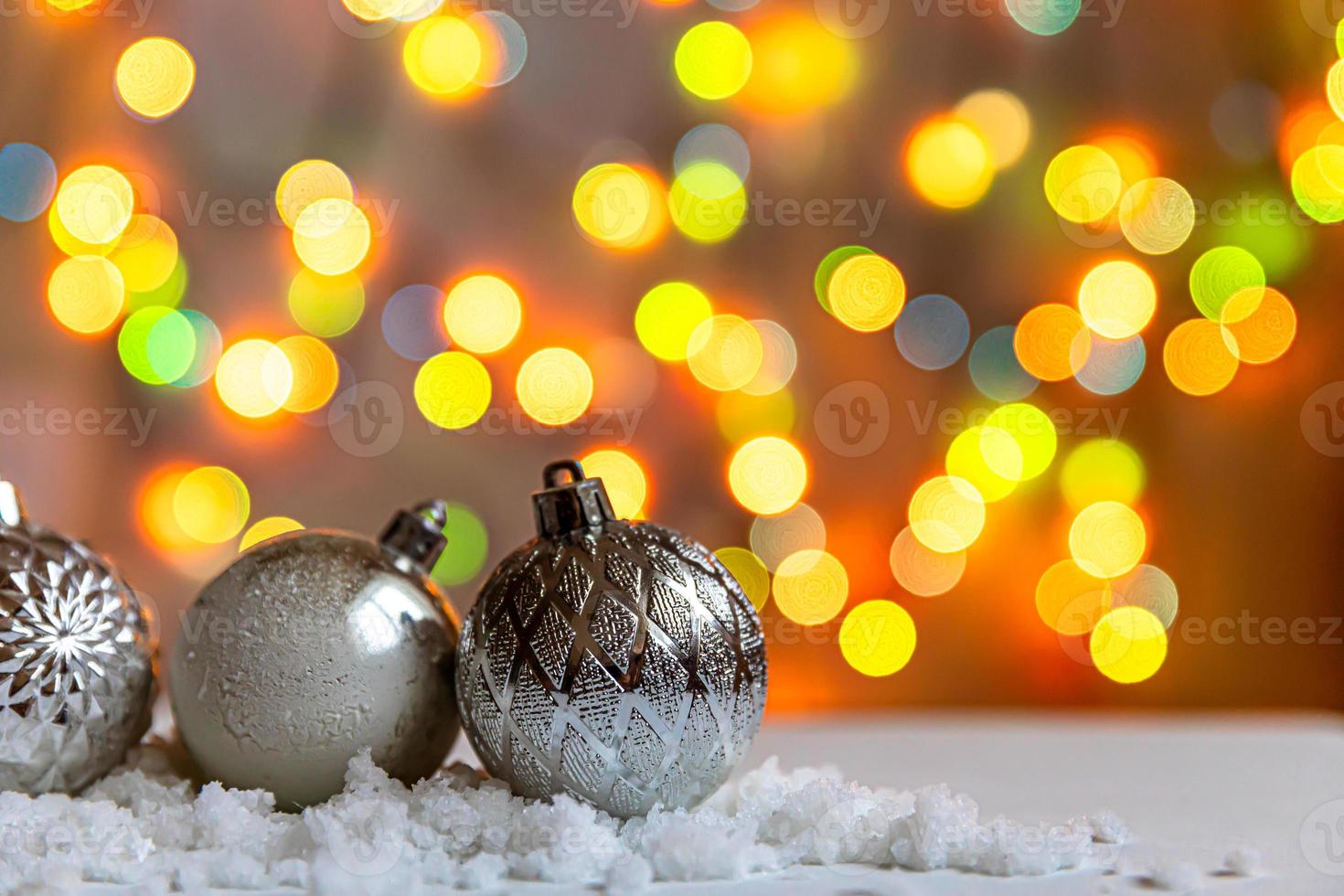 fundo abstrato de Natal do advento. bolas de ornamentos de decorações de inverno no fundo com neve e luzes de guirlanda desfocadas. feliz natal conceito de tempo. foto