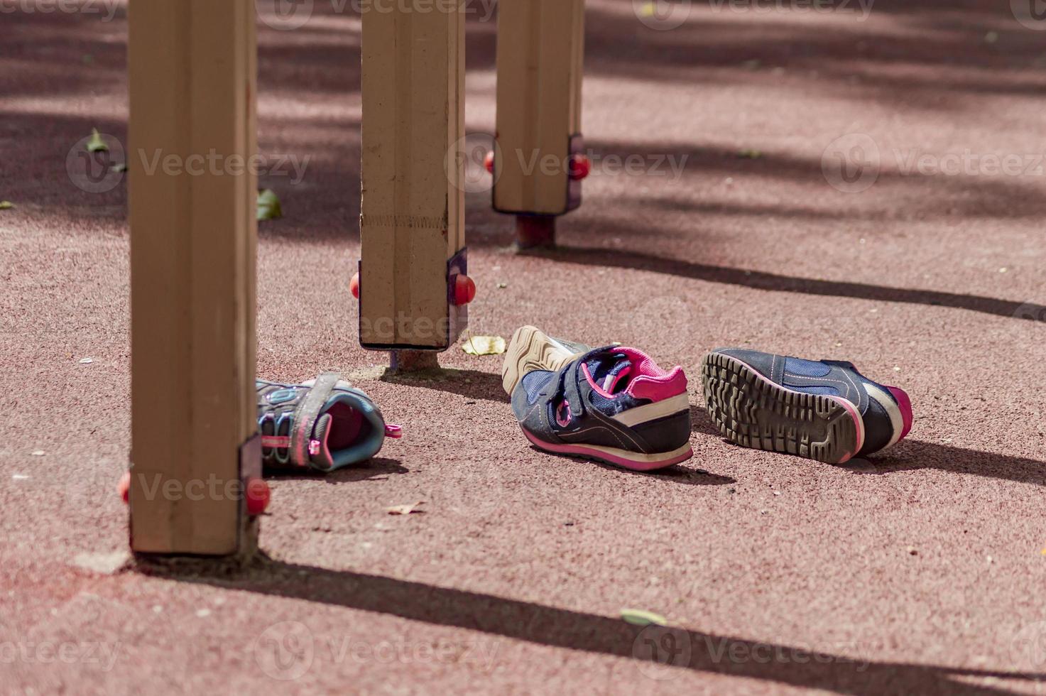 dois pares de tênis infantis estão no playground foto