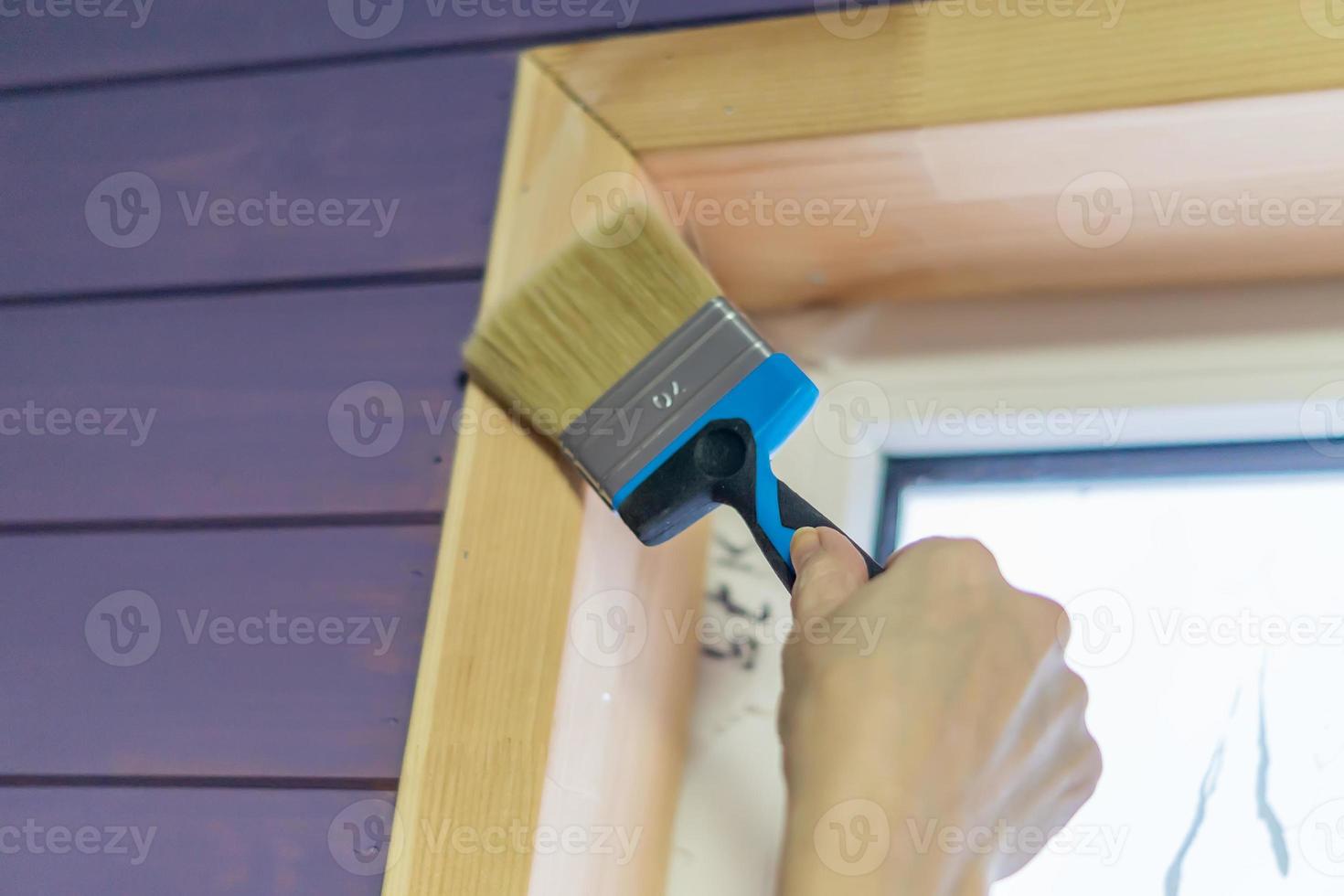 mão de jovem pintando janela em casa foto