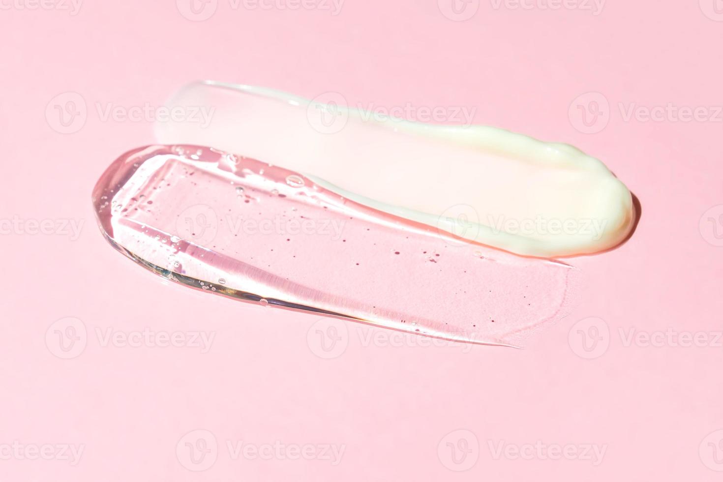 uma mancha de creme branco e gel transparente em um fundo rosa. produto cosmético para cuidados com a pele. foto