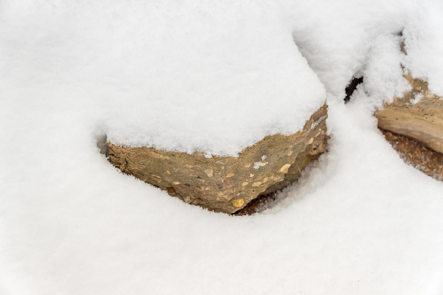 grande pedra coberta de neve branca foto