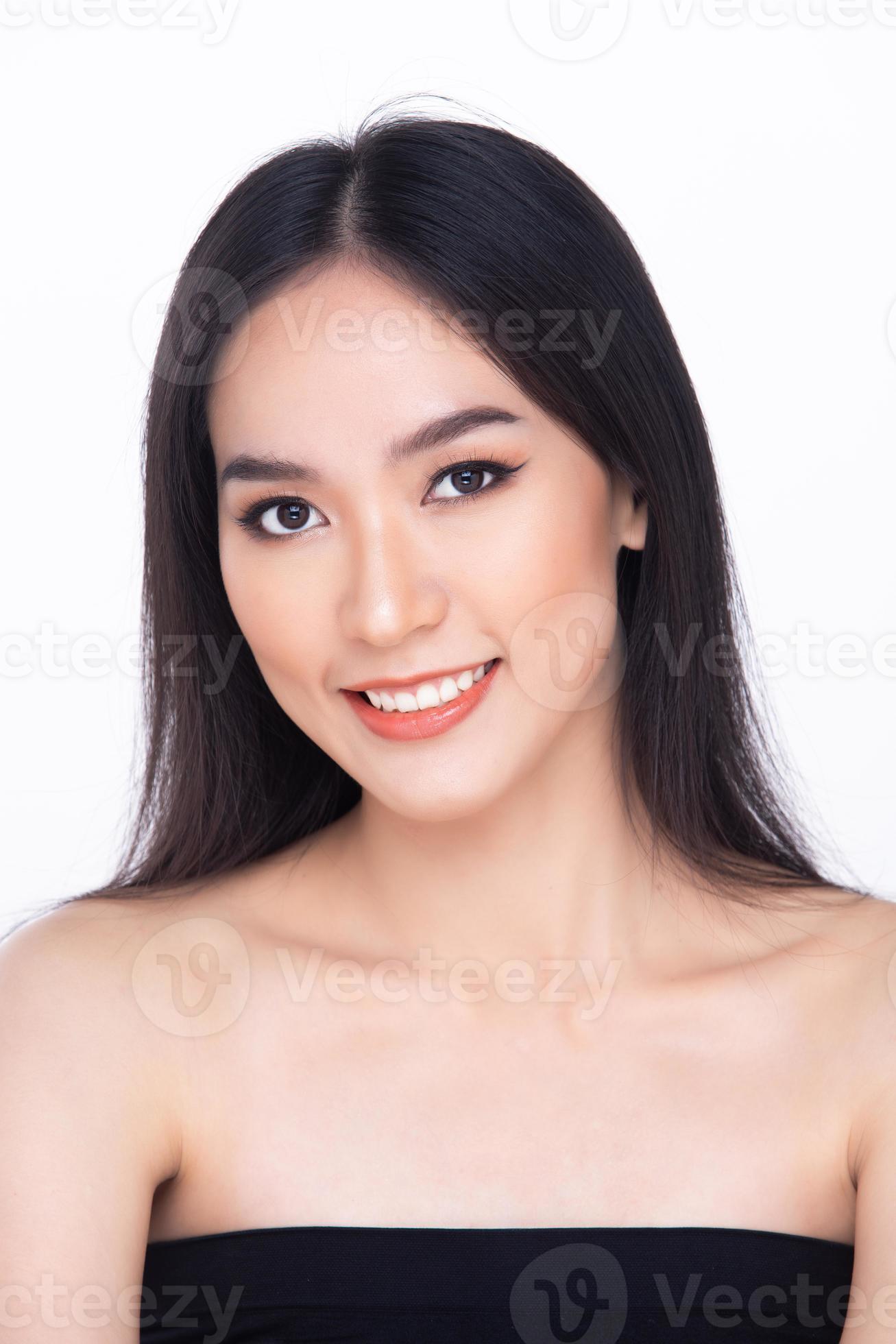 Beleza. close-up de menina bonita e natural com sorriso branco e ombros nus  rindo, sorrindo despreocupado. mulher jovem sem maquiagem mostrando efeito  após cosméticos, parede branca