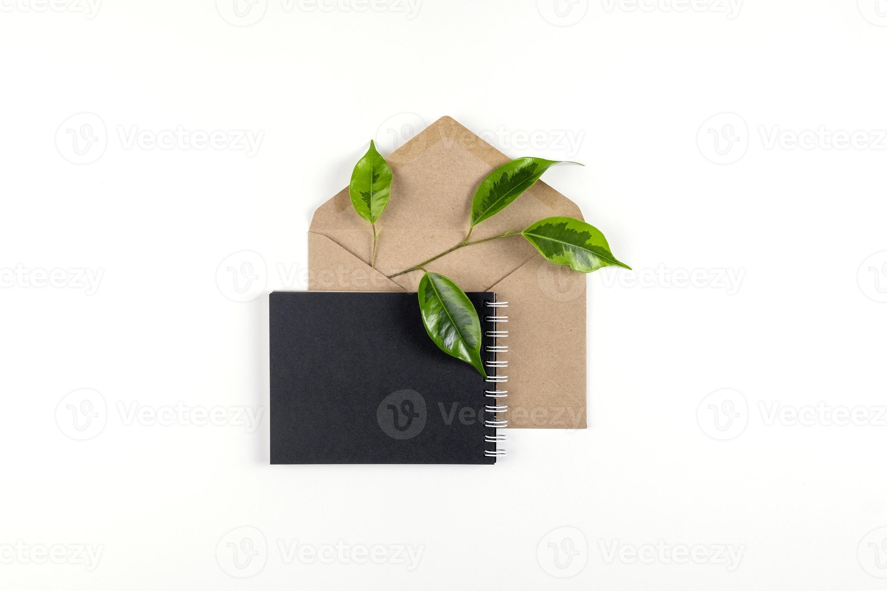 um caderno preto e um envelope feito de papel reciclado estão sobre uma  superfície branca 11098553 Foto de stock no Vecteezy