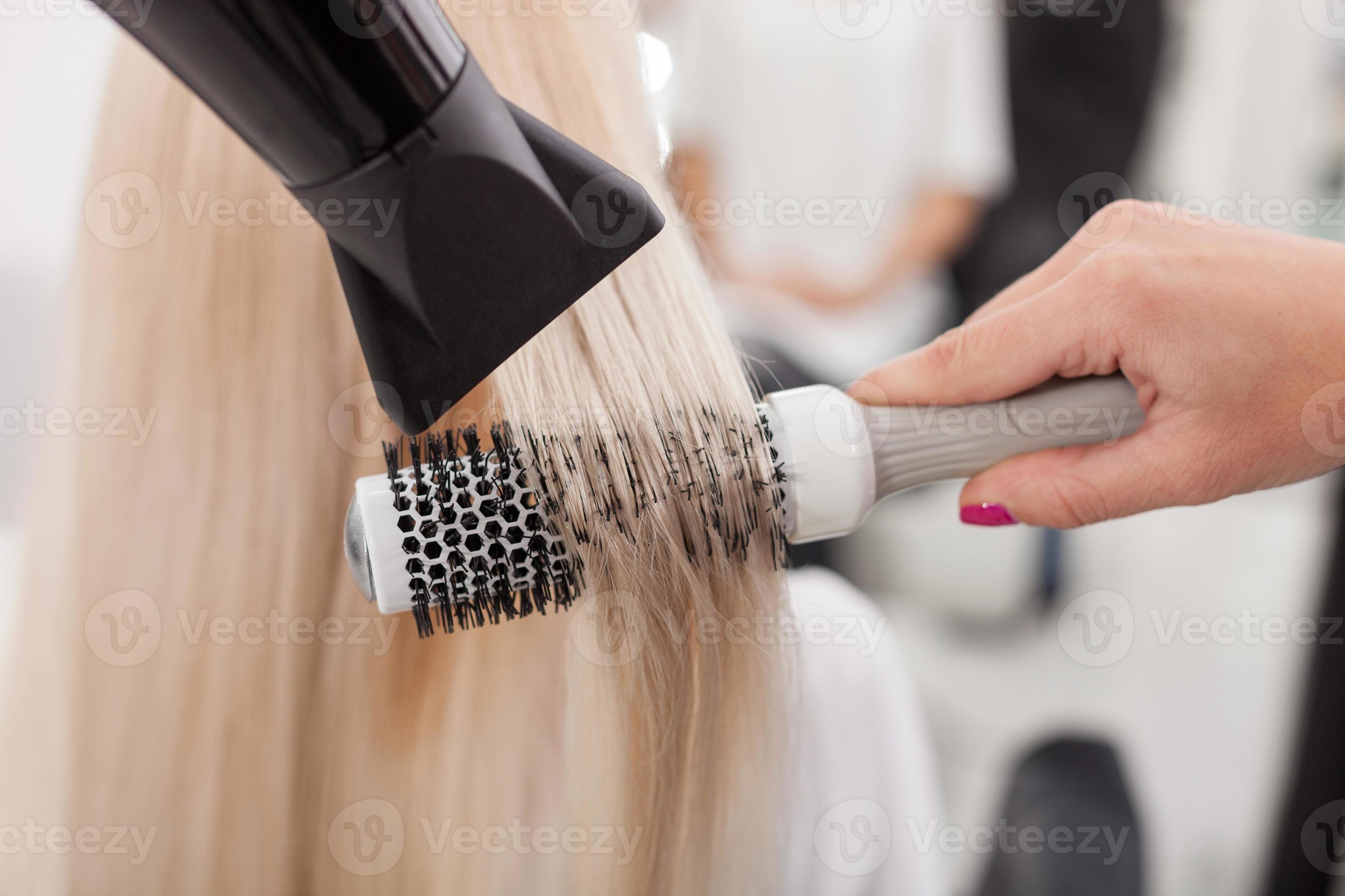 Cabeleireiro alegre, mulher posando com um secador de cabelo nas