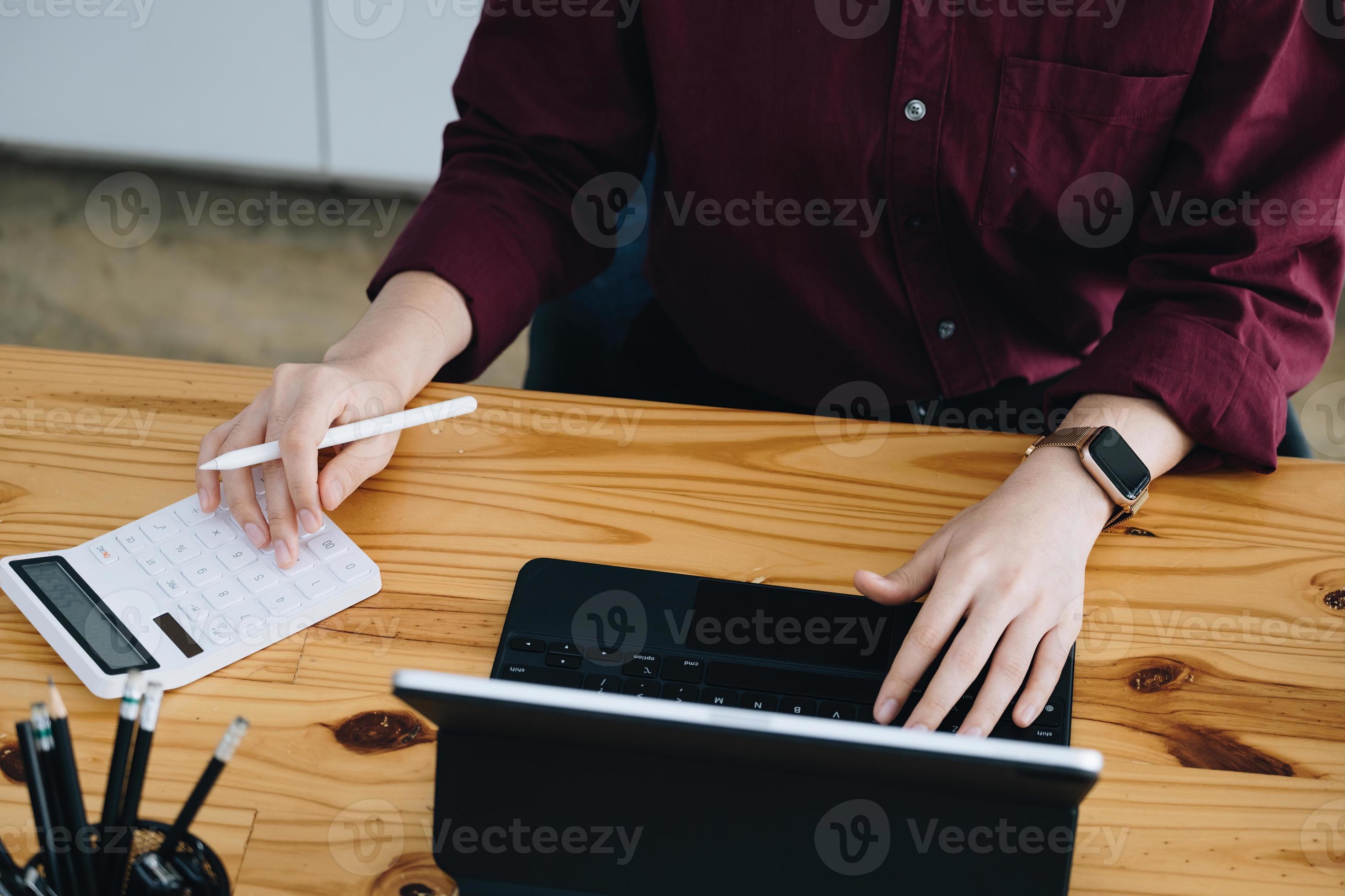 uma funcionária da empresa está usando uma calculadora para calcular a  receita de vendas em uma tela de computador tablet via internet. 11846366  Foto de stock no Vecteezy