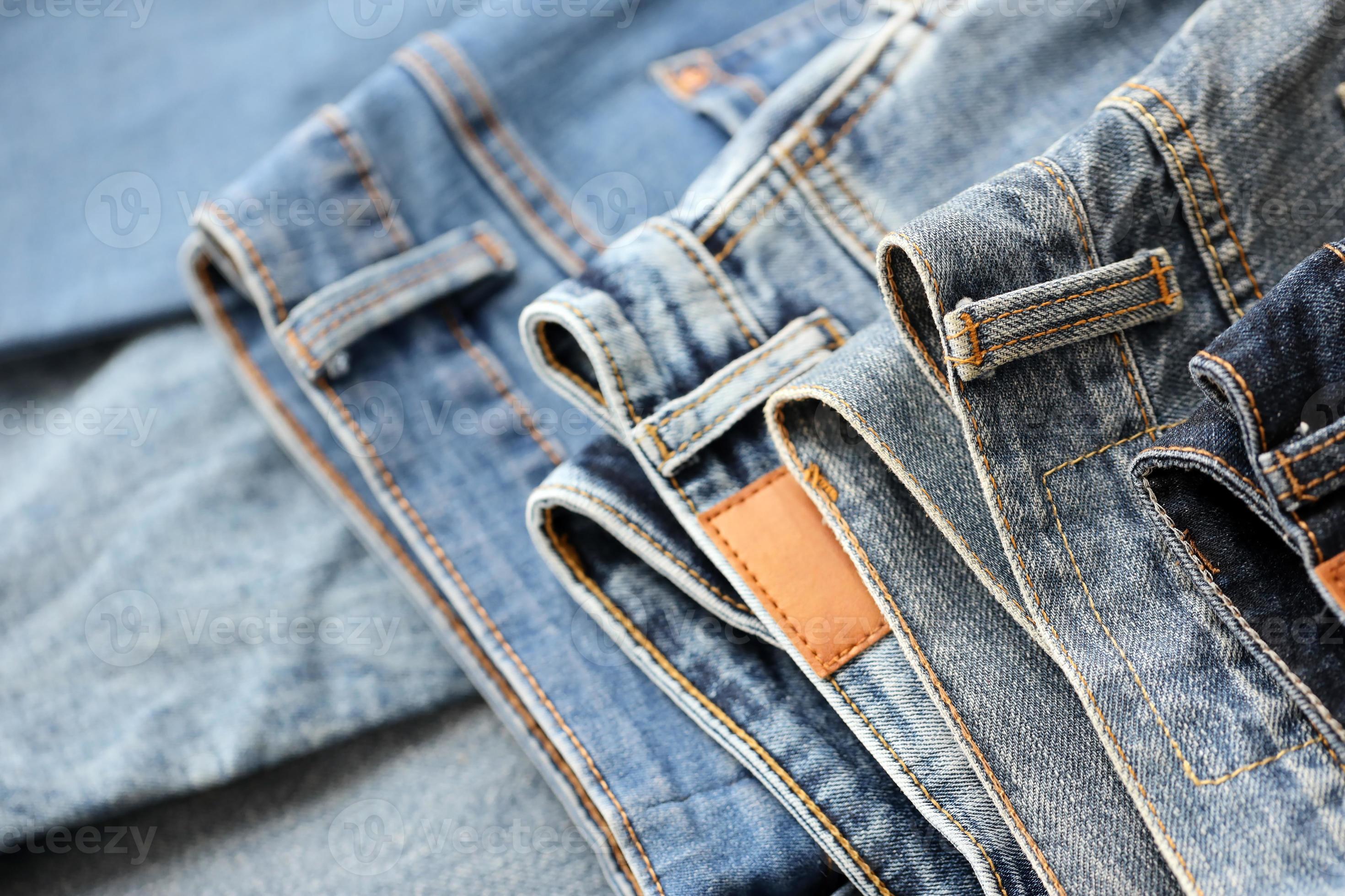 muitos jeans na pilha no guarda-roupa. linha de calças jeans no armário.  conceito de compra, venda, compras e roupas da moda 12304656 Foto de stock  no Vecteezy