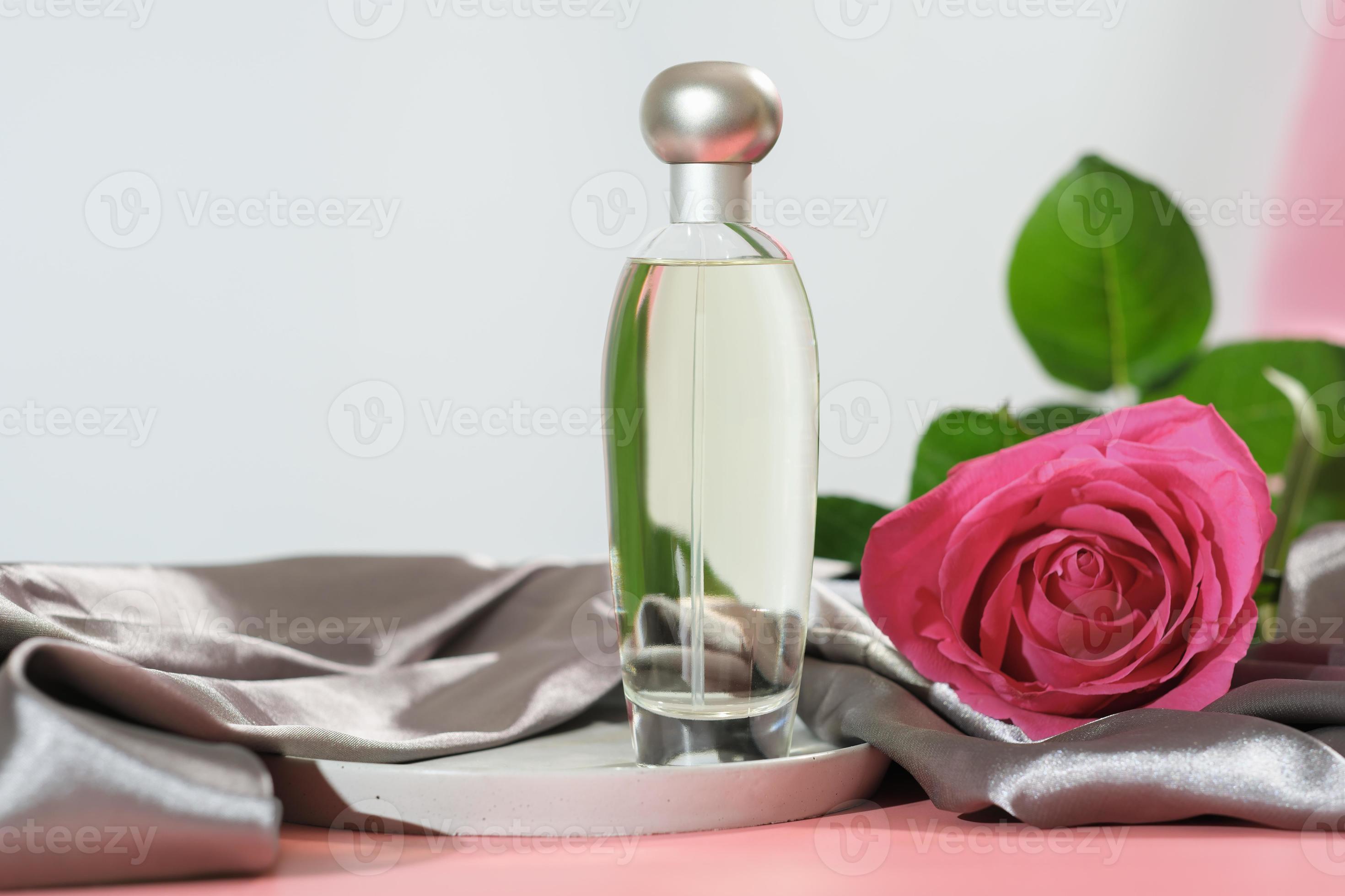 fragrância de perfume floral. frasco de perfume com flor rosa. produto sem  marca. têxtil de tecido de seda de cetim na mesa-de-rosa. 12571858 Foto de  stock no Vecteezy