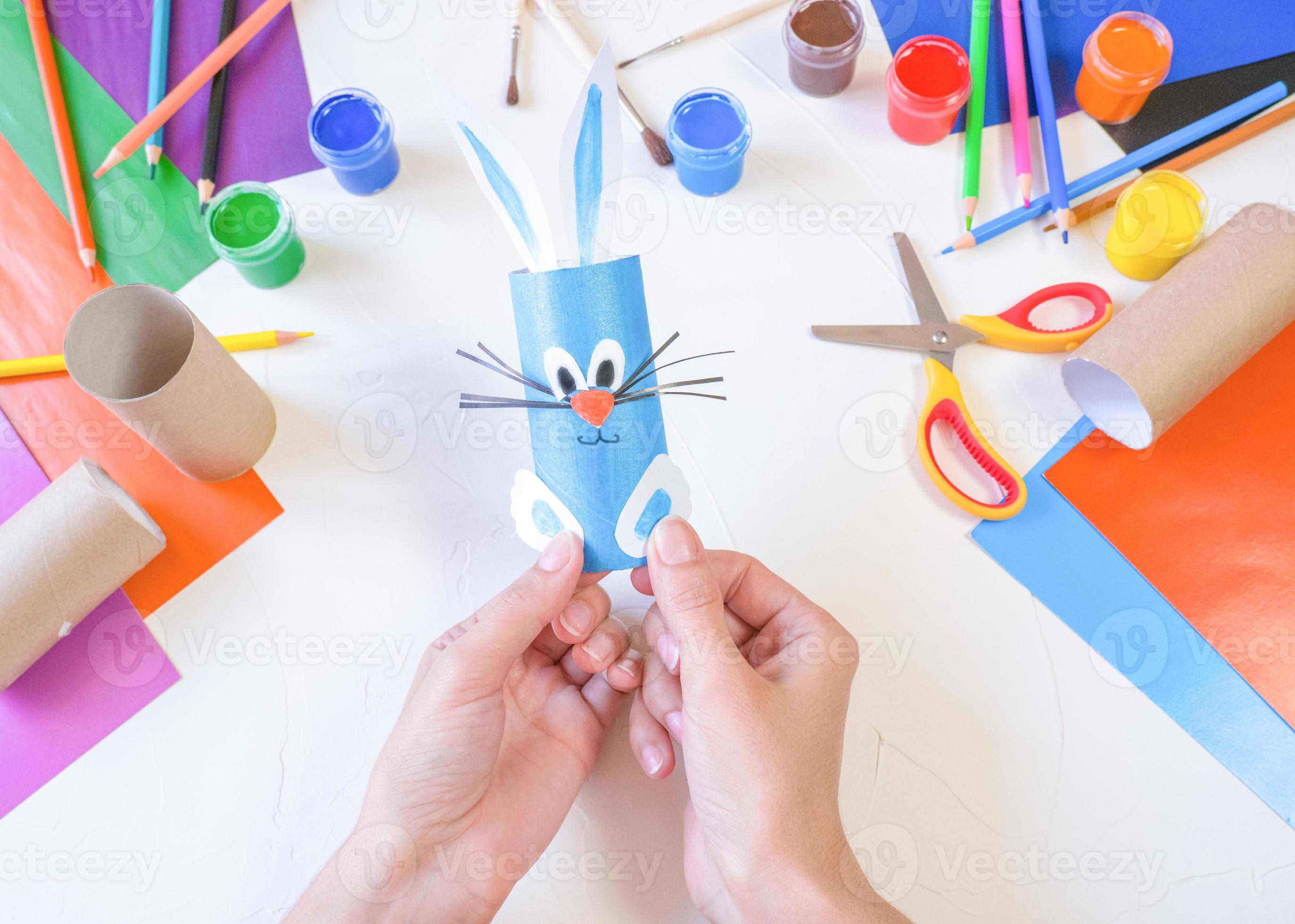 Coelhinhos da páscoa feitos à mão de papel colorido, artesanato fácil para  crianças em um fundo verde.