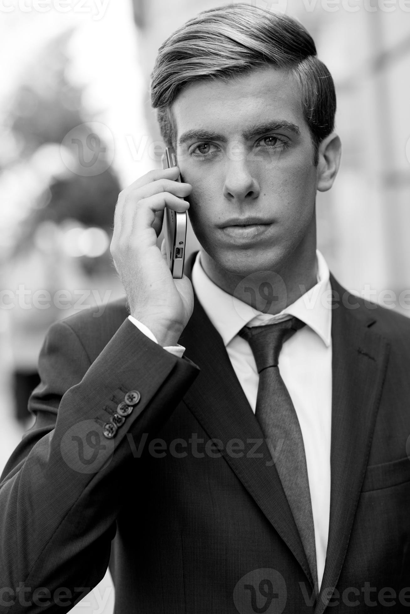 atraente jovem empresário ao telefone em meio urbano foto