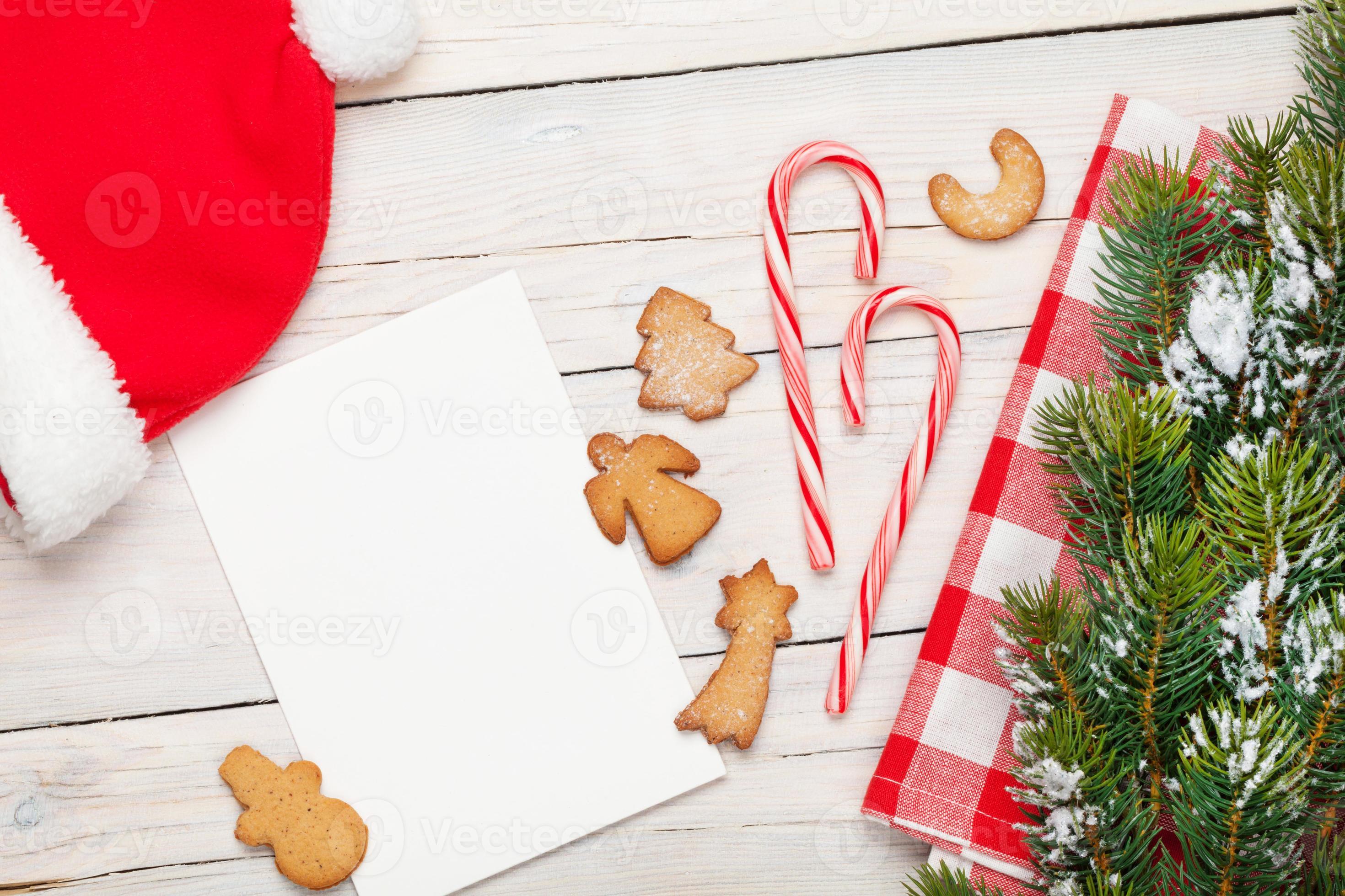 cartão de Natal, chapéu de Papai Noel, biscoitos de gengibre e neve foto