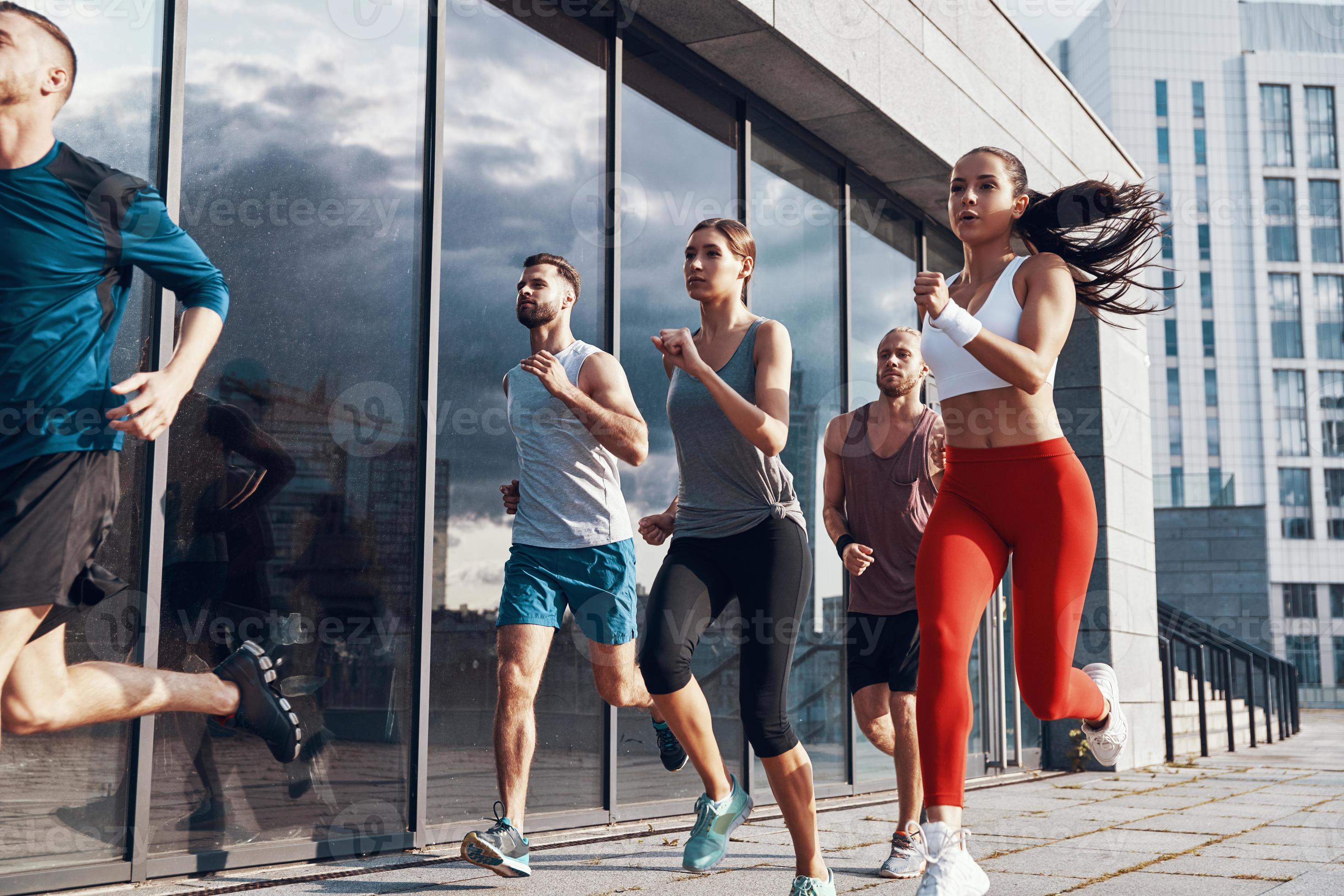 grupo de pessoas em roupas esportivas correndo enquanto se exercita na  calçada ao ar livre 13485070 Foto de stock no Vecteezy