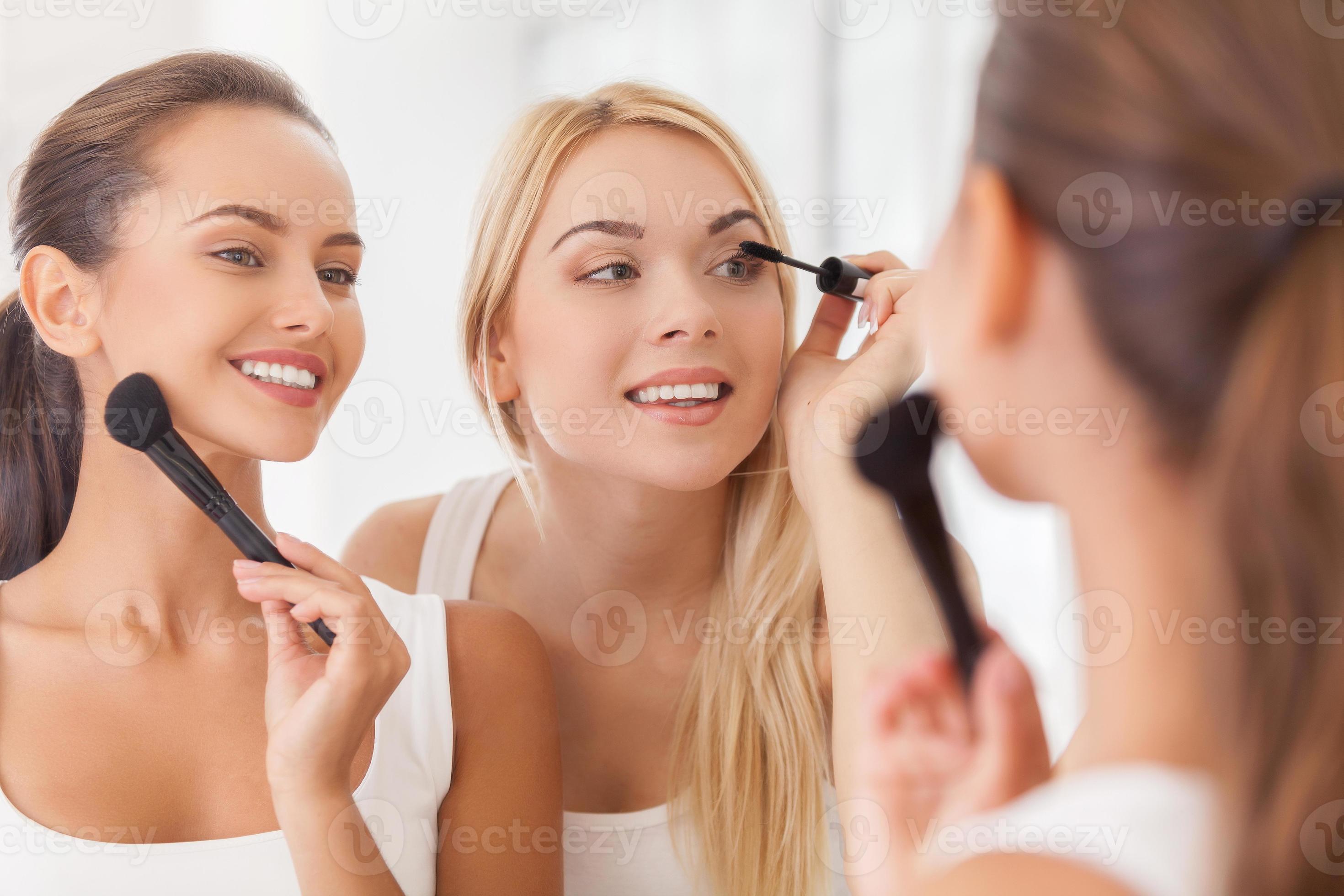 fazendo maquiagem juntos. duas mulheres bonitas fazendo maquiagem