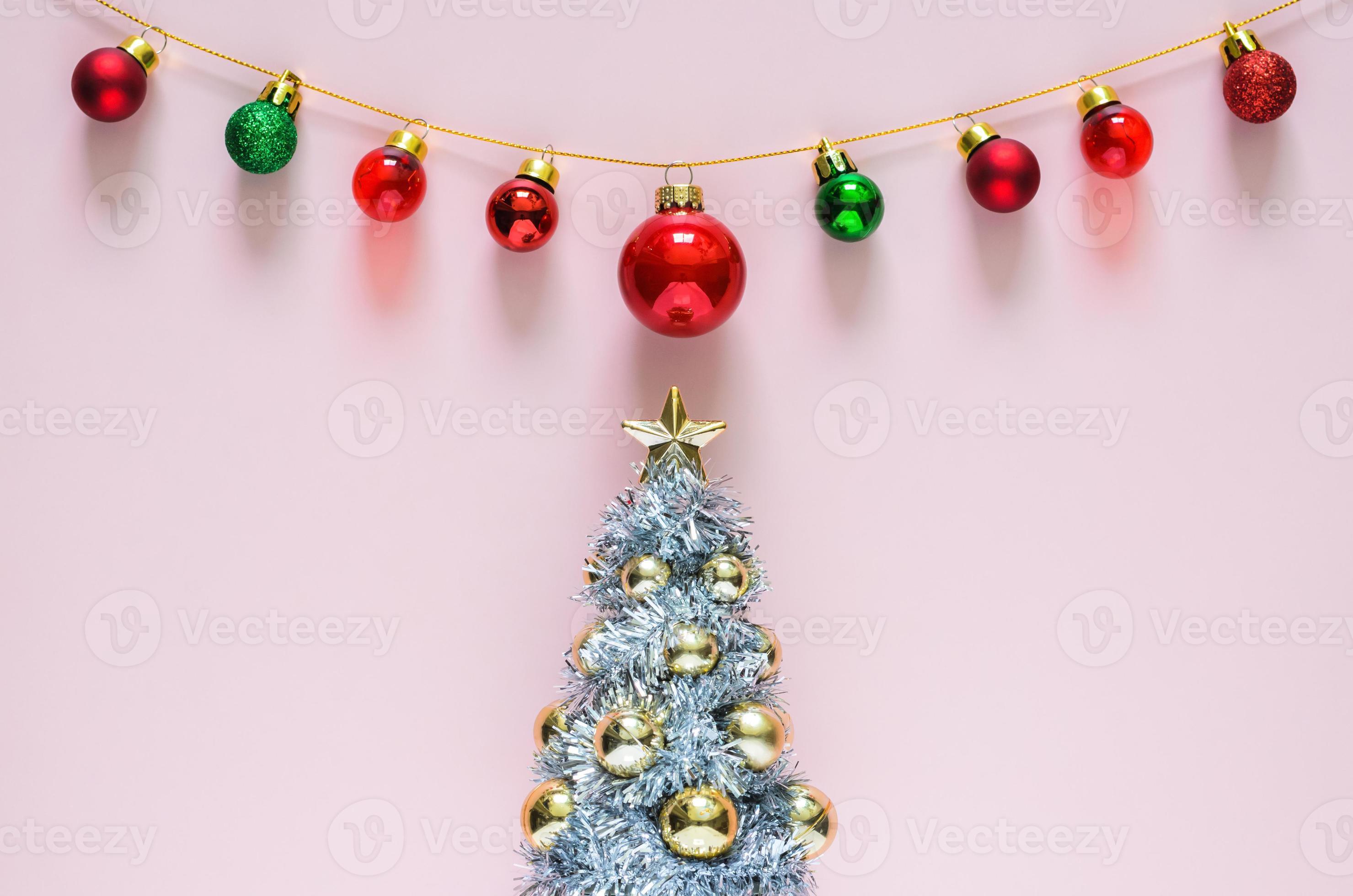 árvore de natal com enfeites de enfeites coloridos em cima com fundo rosa.  conceito mínimo de férias. 13870467 Foto de stock no Vecteezy