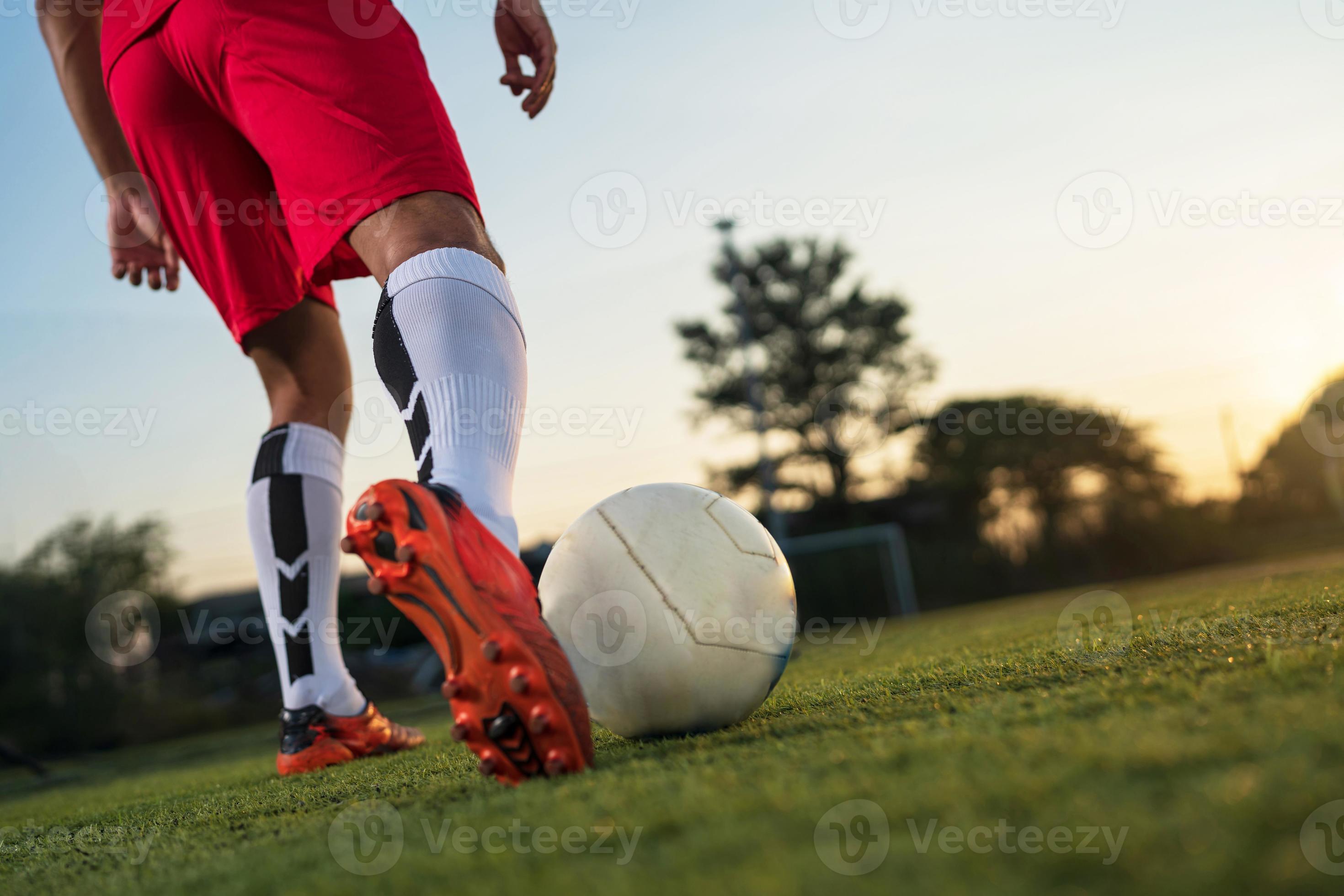 jogador de futebol jogando bola no estádio ao ar livre. 13946174