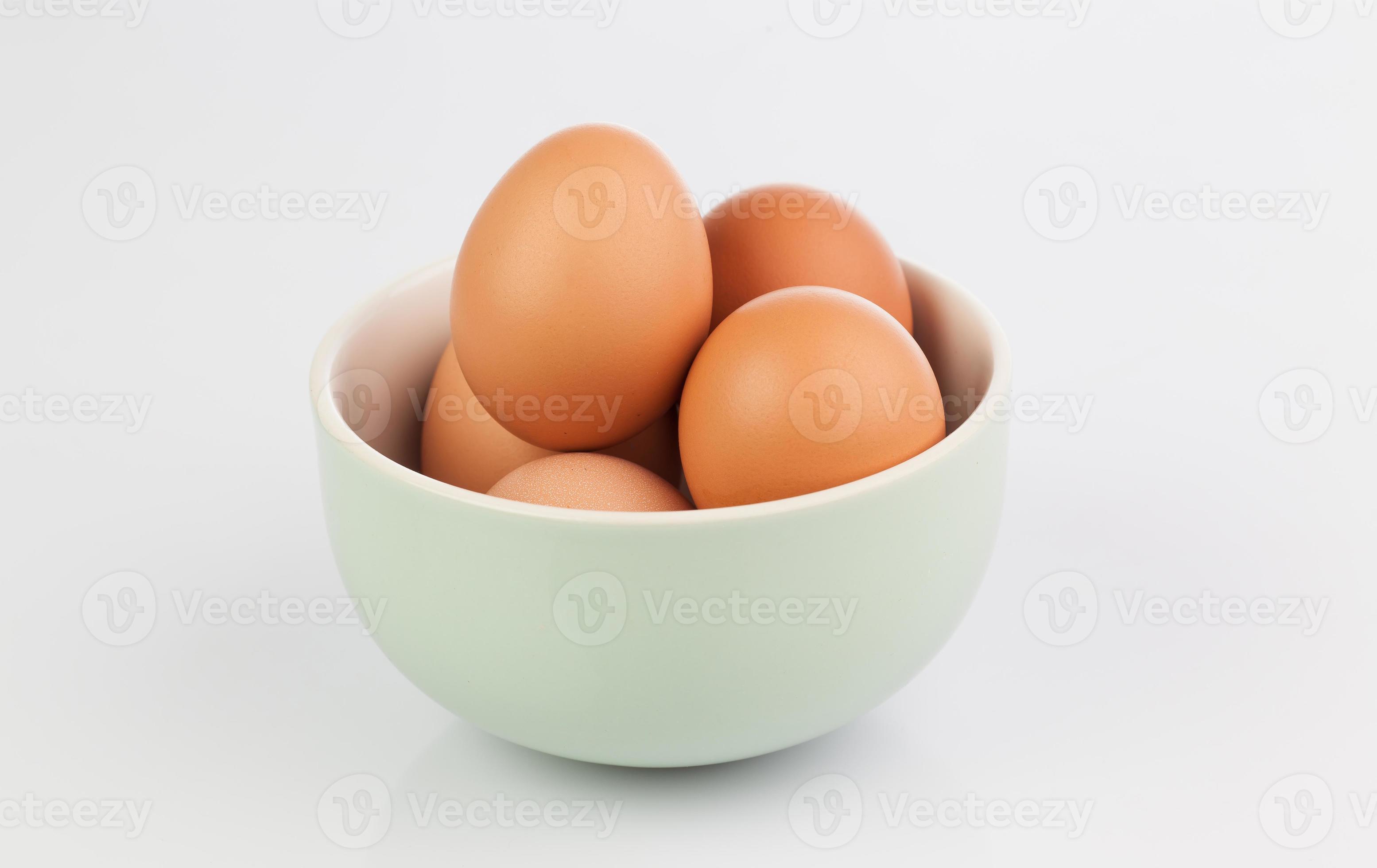 ovos crus isolados em tigela de barro foto