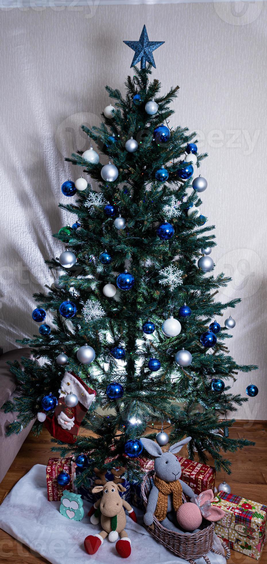 árvore de natal com bolas coloridas e caixas de presente sobre parede de  tijolos brancos com bolas azuis e brancas 15269972 Foto de stock no Vecteezy