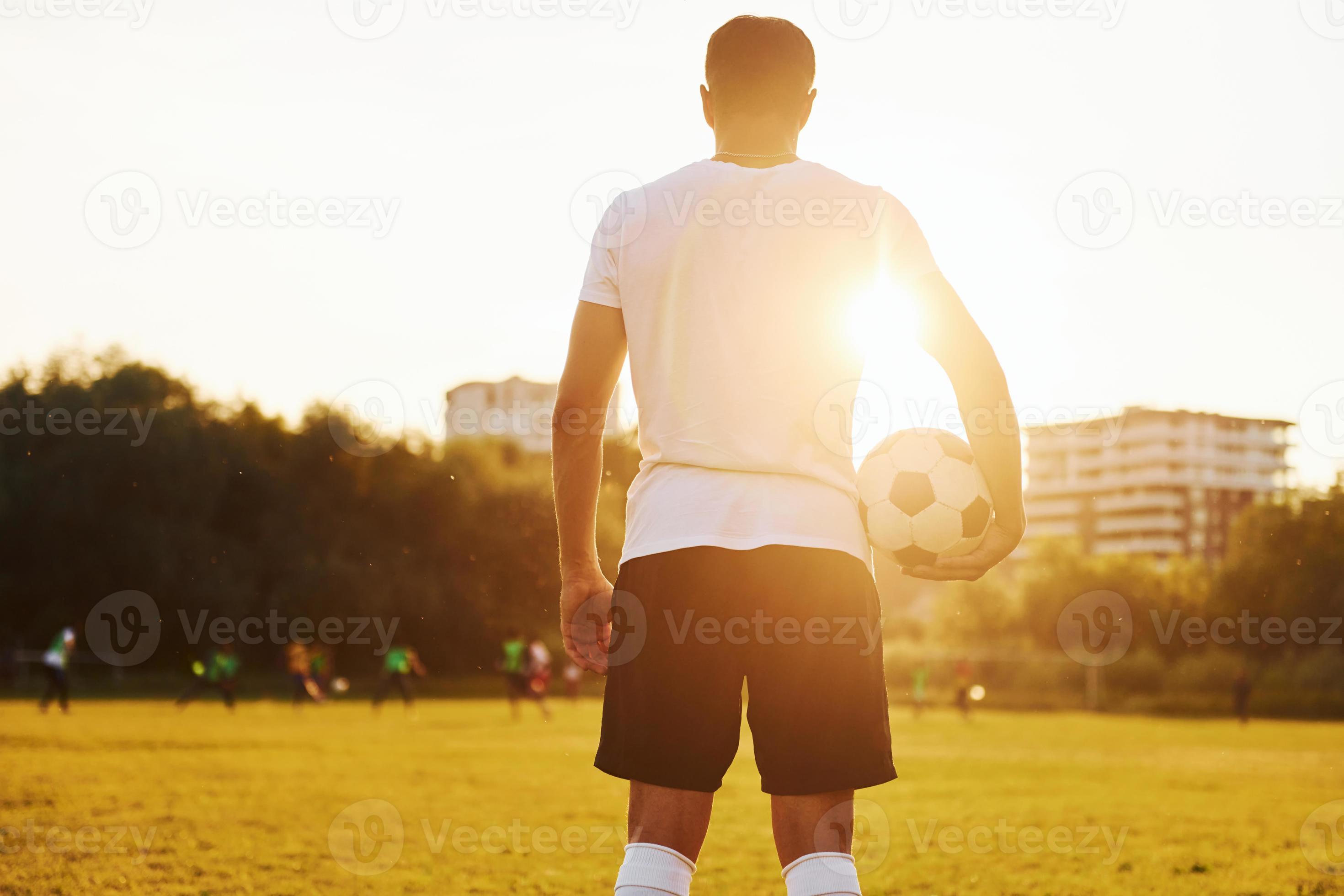 Esporte, treinamento de futebol e pessoas - jogador de futebol jogando com  bola no campo