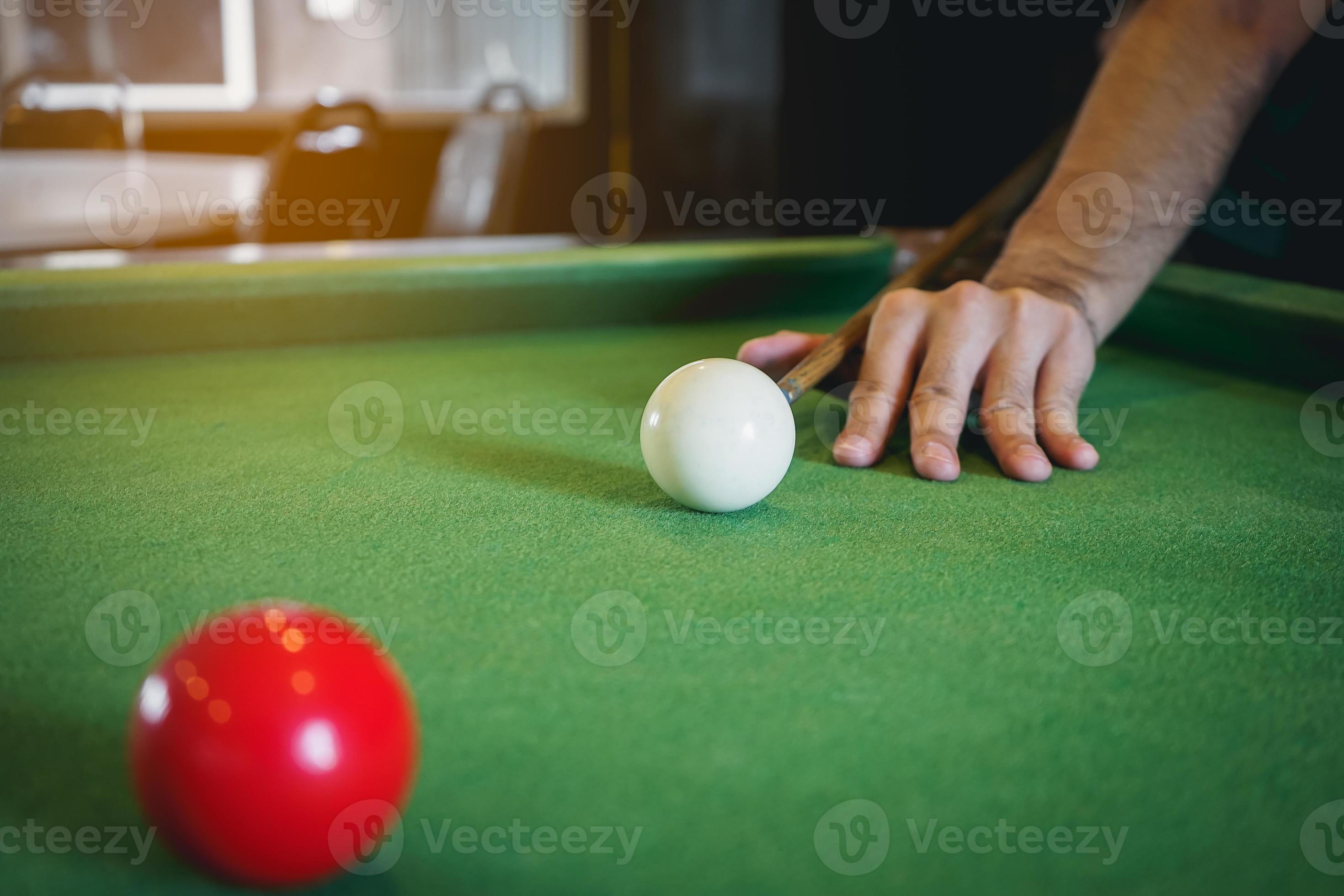 Mão do homem jogando sinuca no bar com bola de snooker