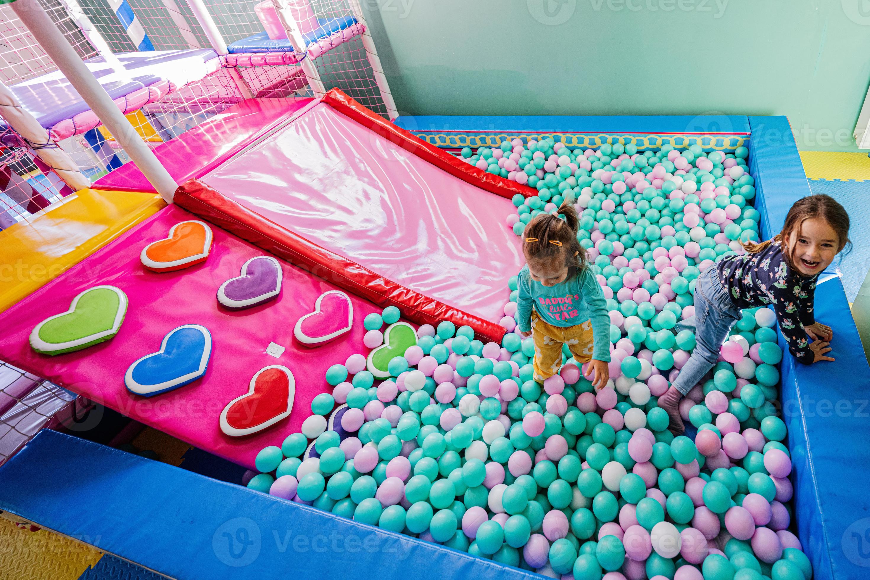 irmão com irmã jogando na piscina de bolinhas coloridas. playground interno  de creche. piscina de bolinhas para crianças. sala de jogos do jardim de  infância ou pré-escola. 5848214 Foto de stock no