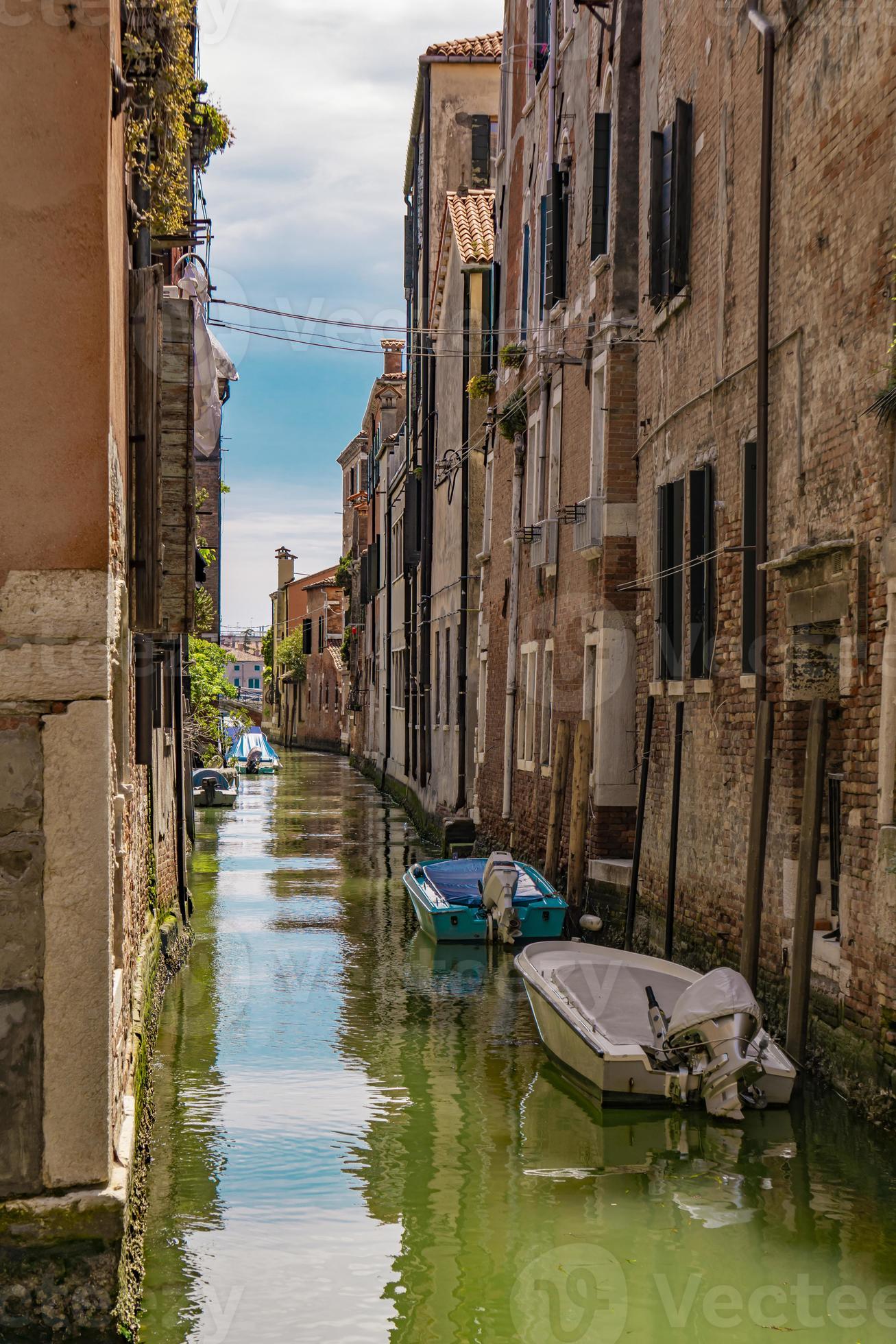 canal de rua com barcos em veneza, itália foto