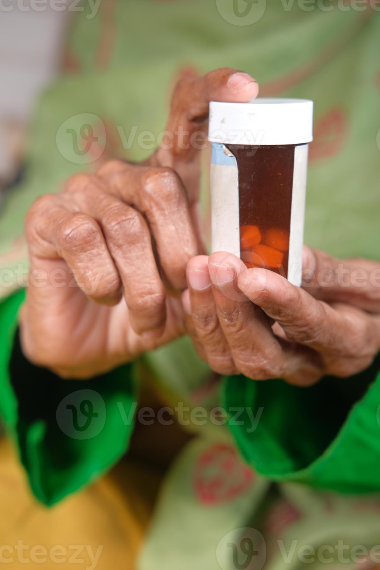 mulher segurando frasco de comprimidos foto