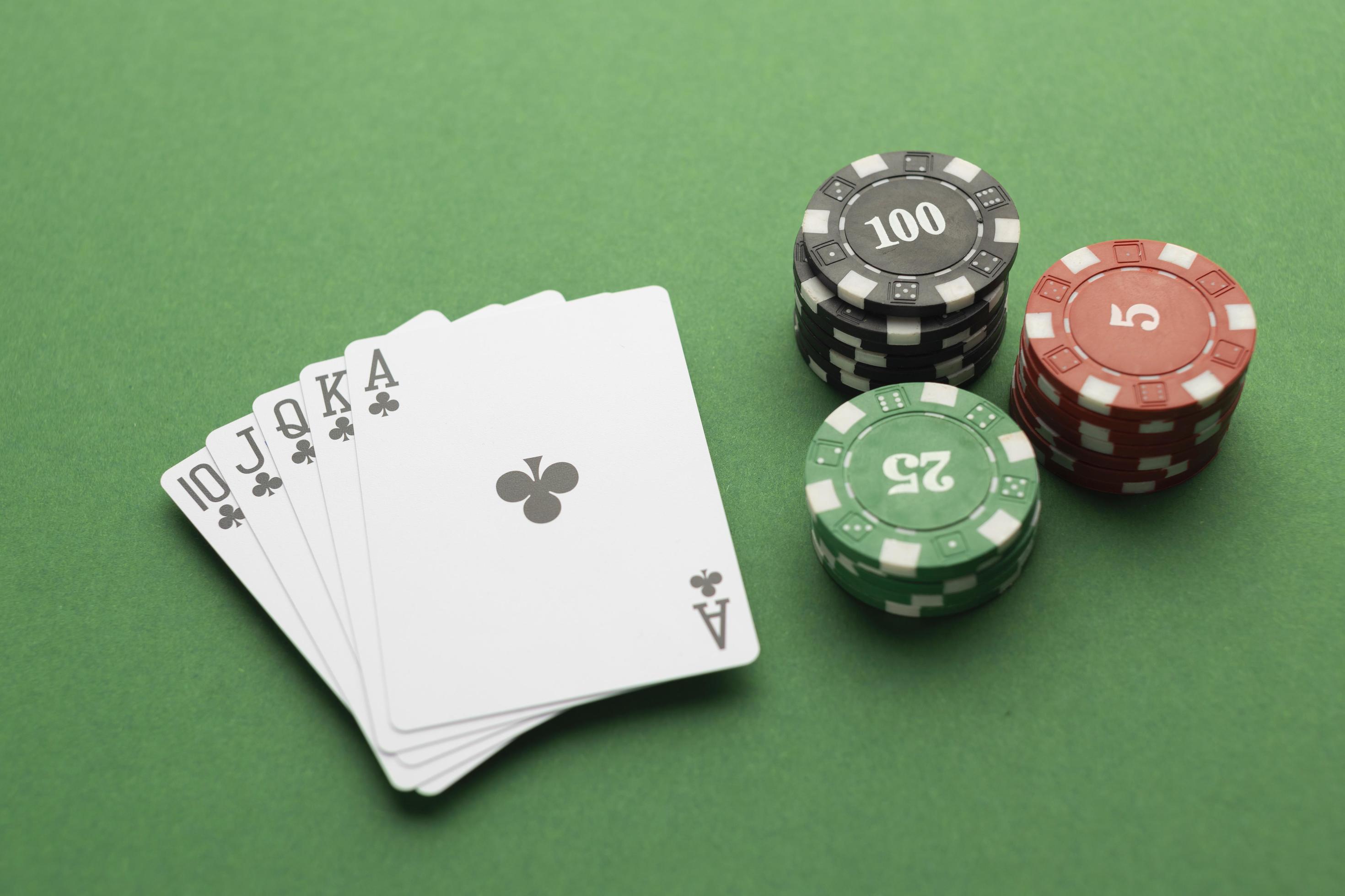 Royal flush baralho e fichas de casino em fundo verde poker