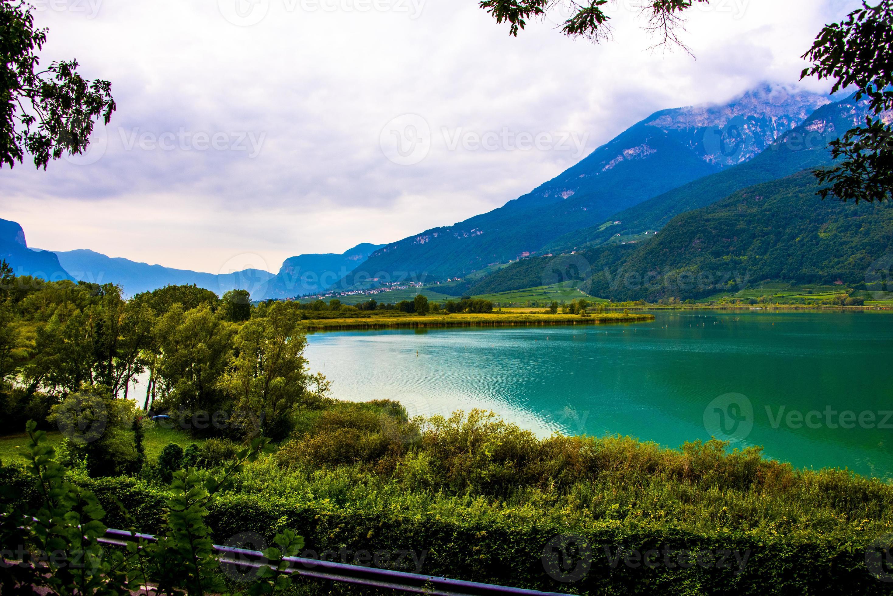lago caldaro cercado pelas montanhas em bolzano, itália foto