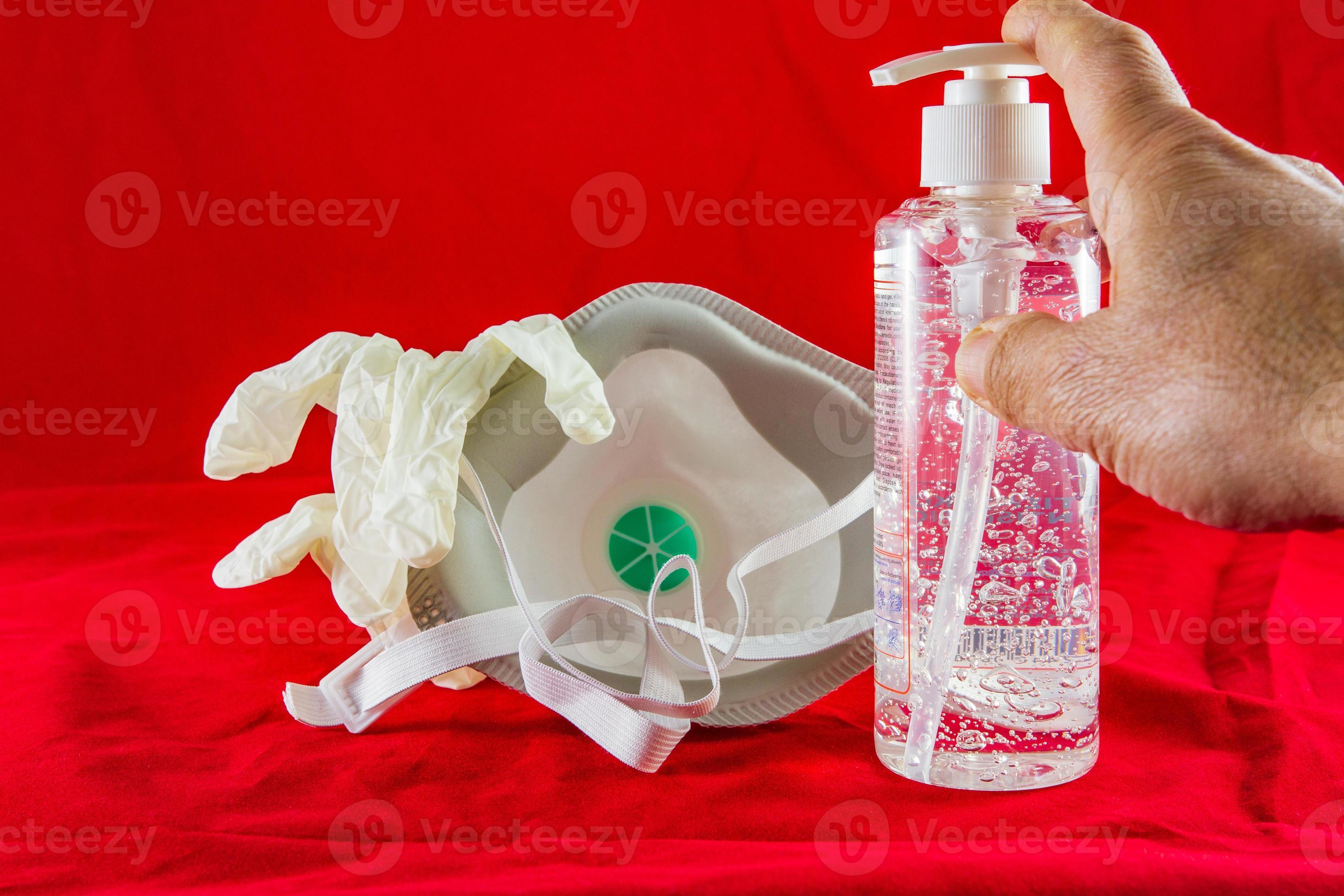 gel desinfetante de mãos, luvas de látex brancas e máscara no conceito de proteção vermelha contra o vírus da poluição, gripe e coronavírus foto
