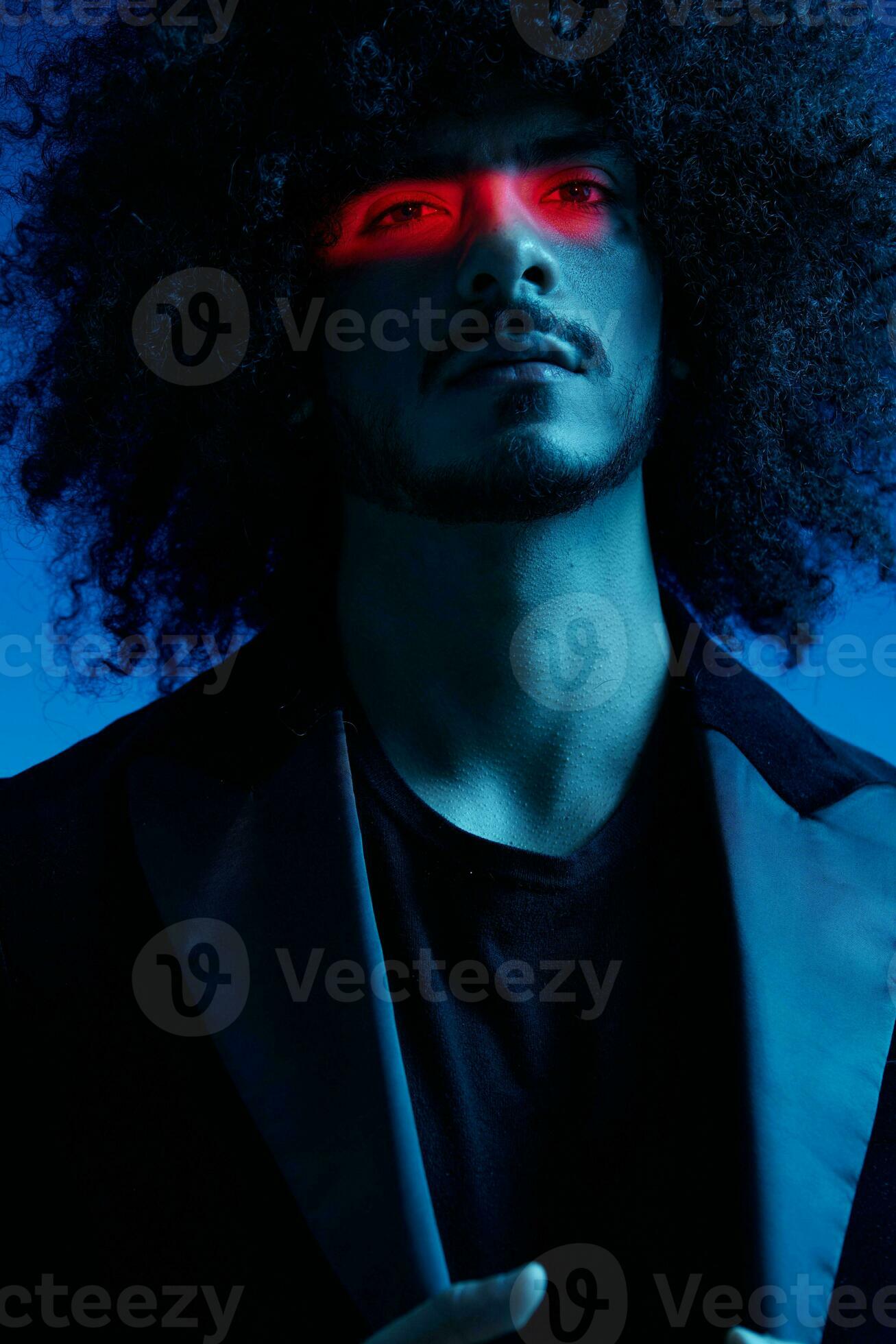 moda retrato do uma homem com encaracolado cabelo em uma azul fundo com uma  vermelho listra do luz, multicolorido luz, na moda, moderno conceito.  25045601 Foto de stock no Vecteezy