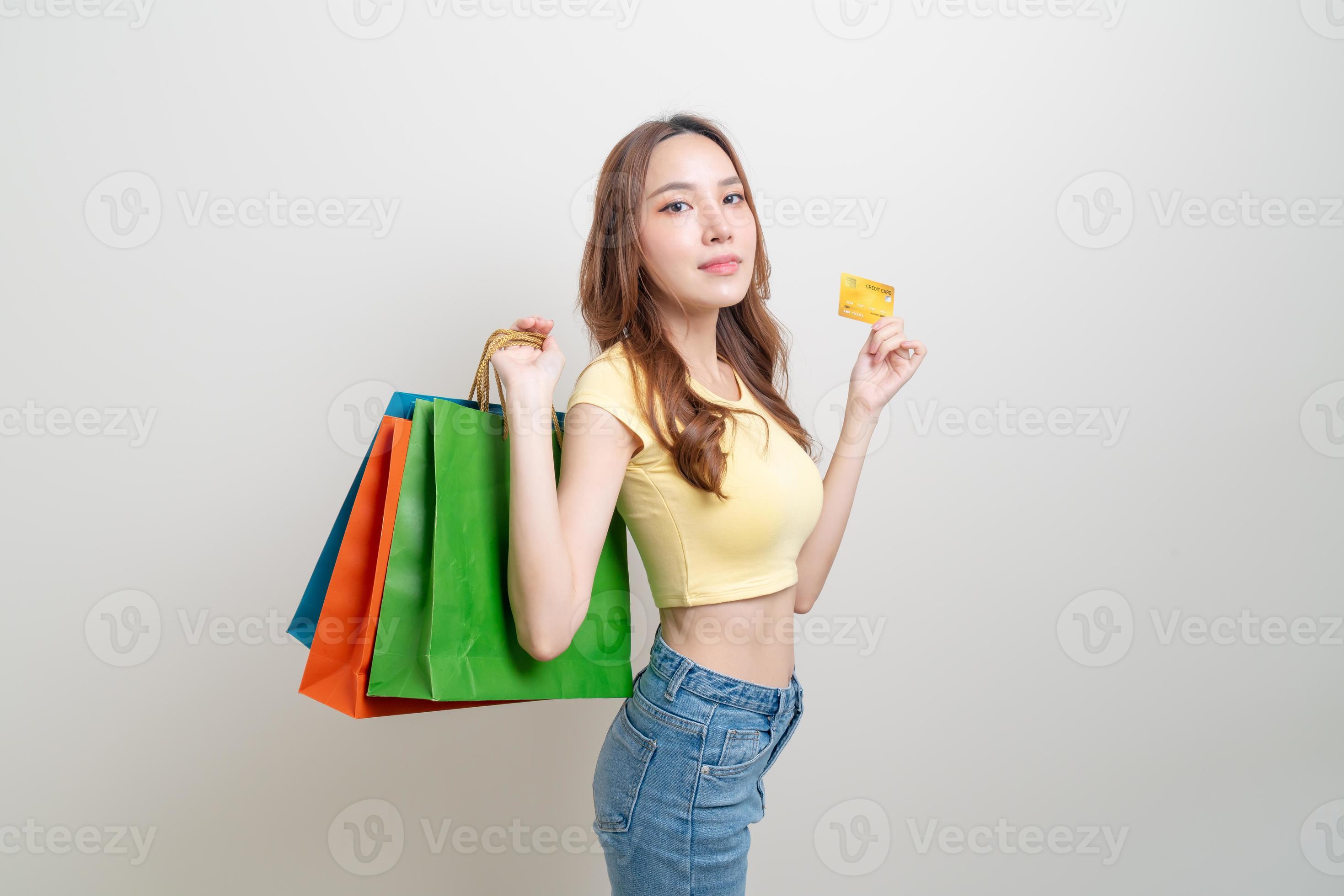 retrato de uma mulher bonita segurando uma sacola de compras e um cartão de crédito foto