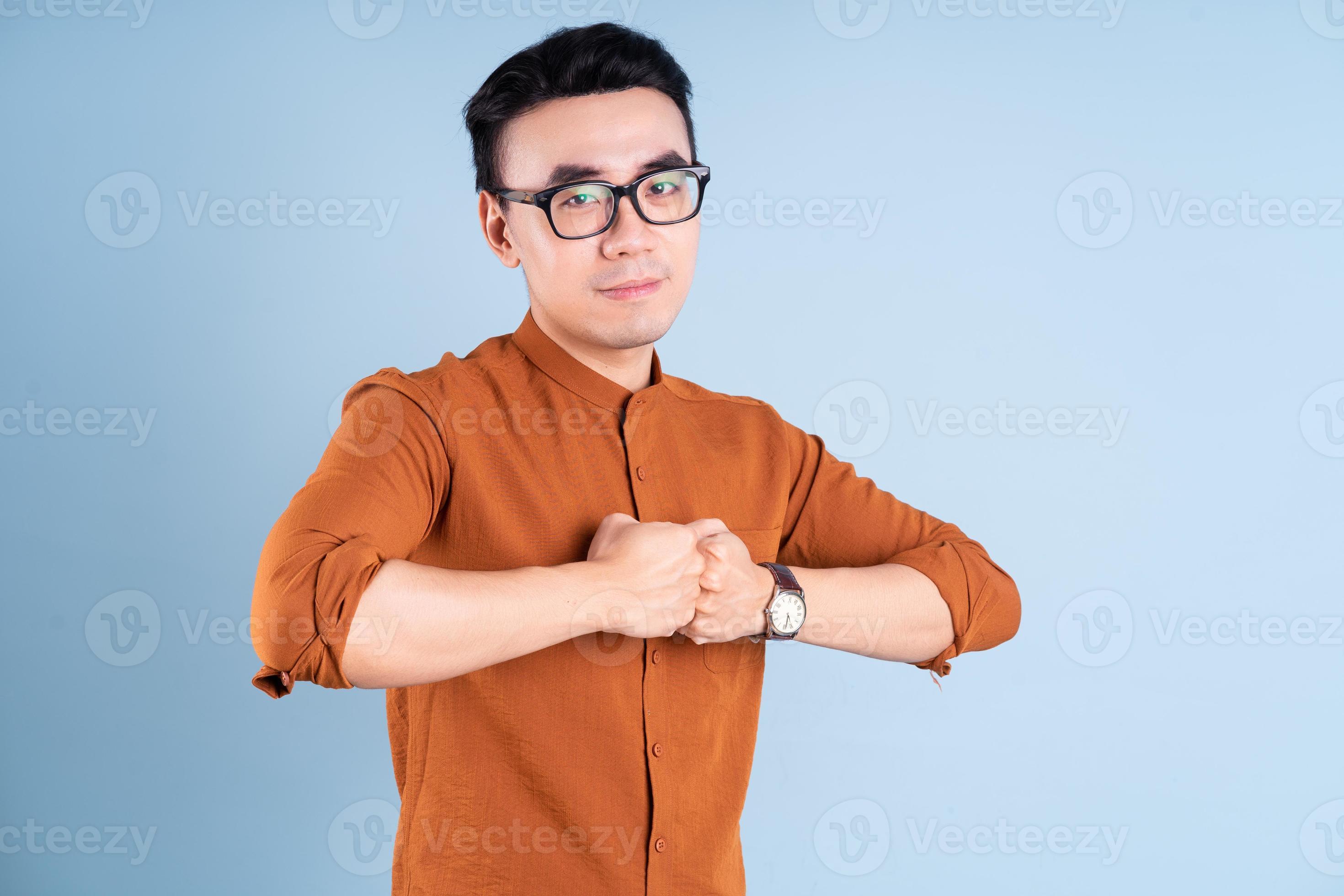 jovem empresário asiático posando em fundo azul foto