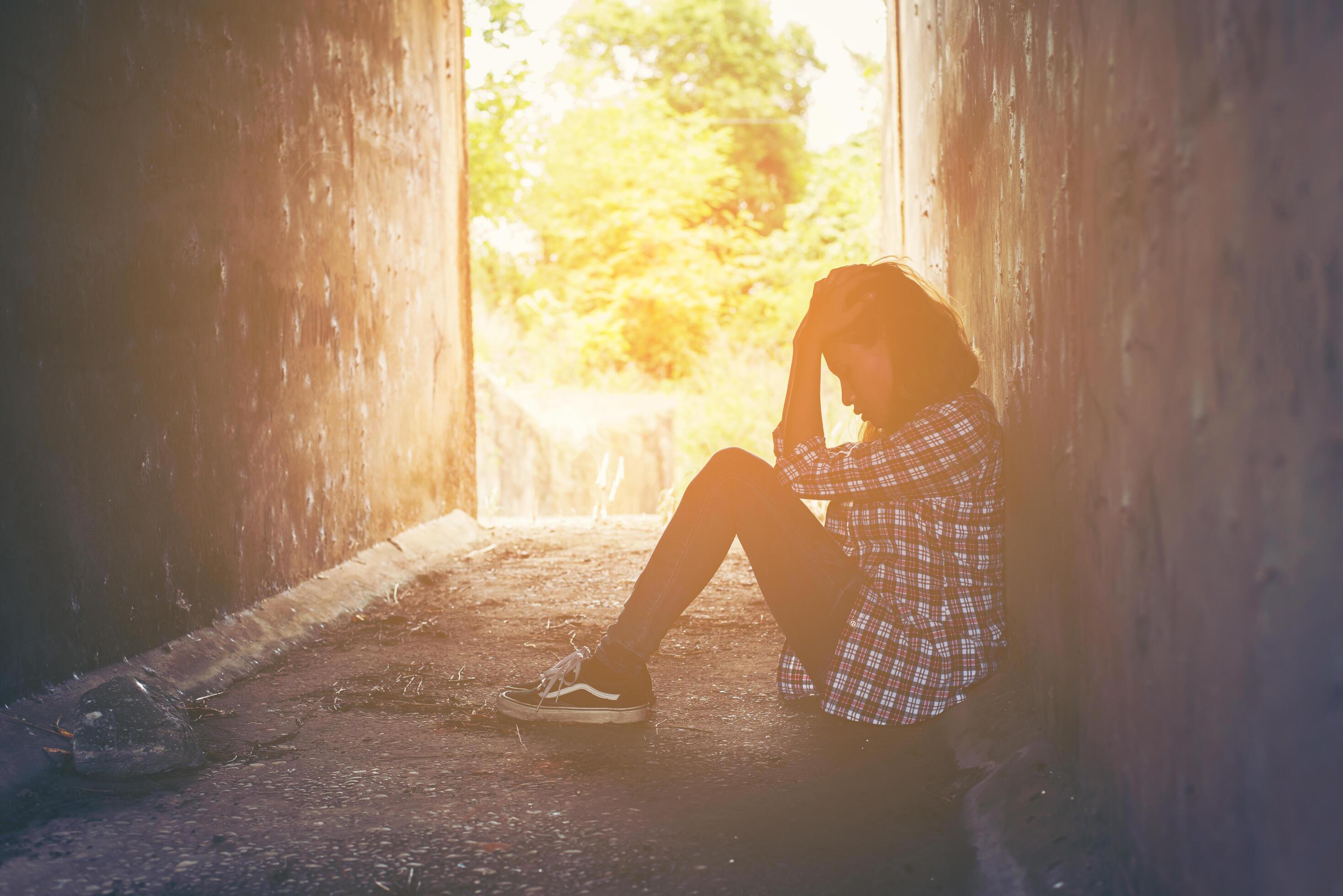 A mulher com depressão abraça o joelho e chora. a mulher triste