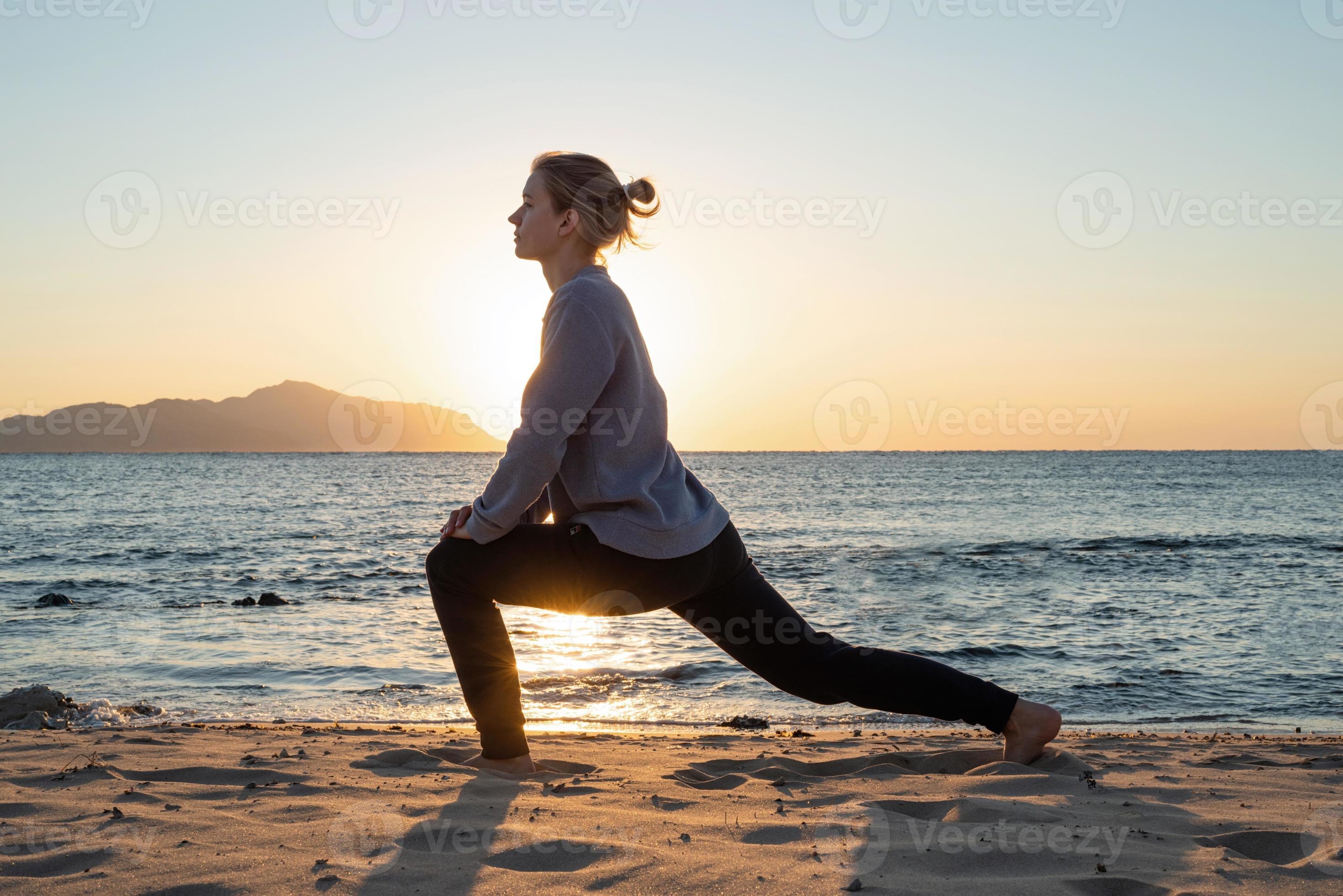 Mulher praticando ioga na praia ao pôr do sol fotos, imagens de