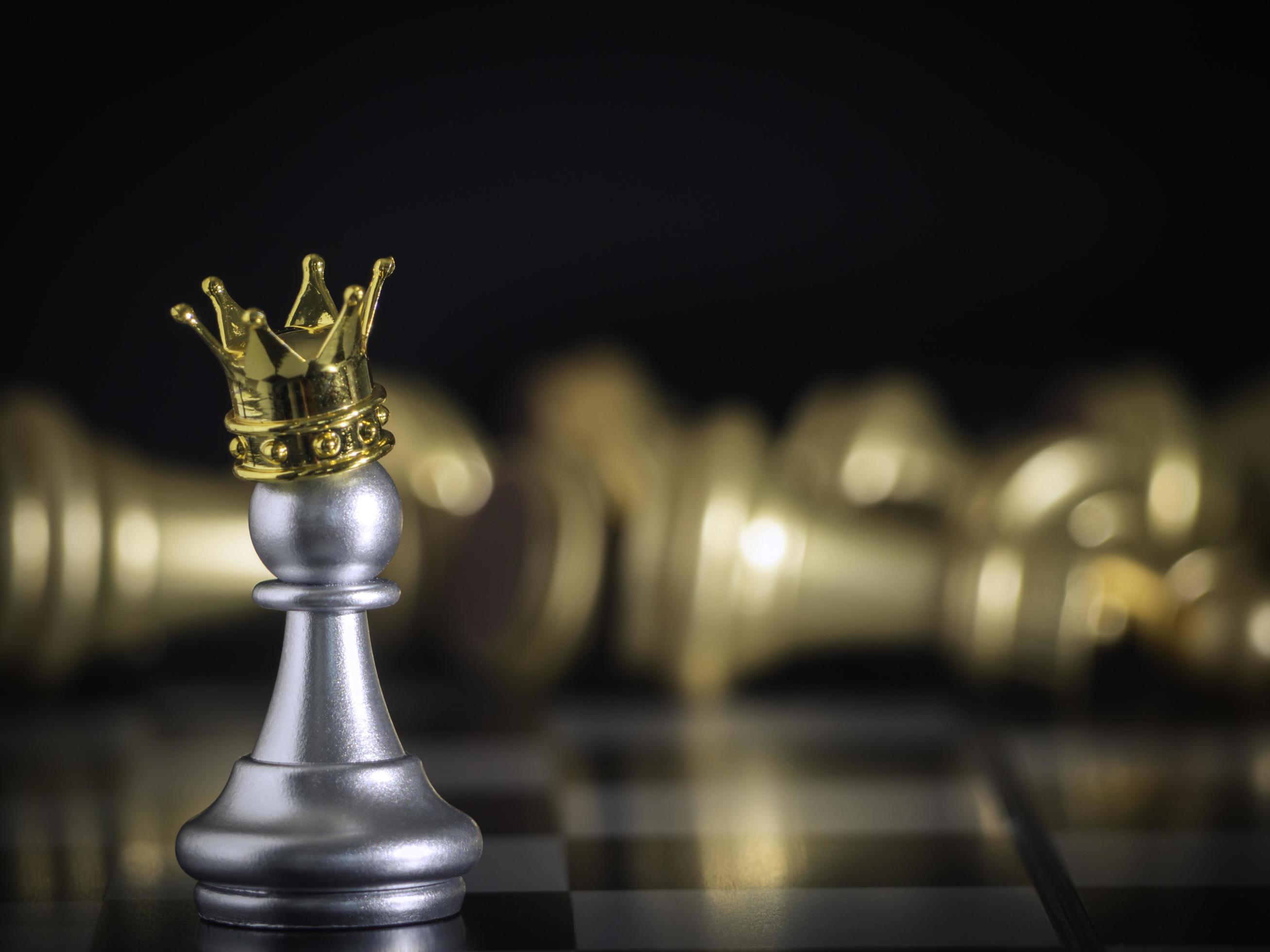 um peão de prata em pé coroado no jogo de xadrez de batalha a bordo com  fundo de xadrez dourado. para lutar com trabalho em equipe para a vitória,  conceito de estratégia