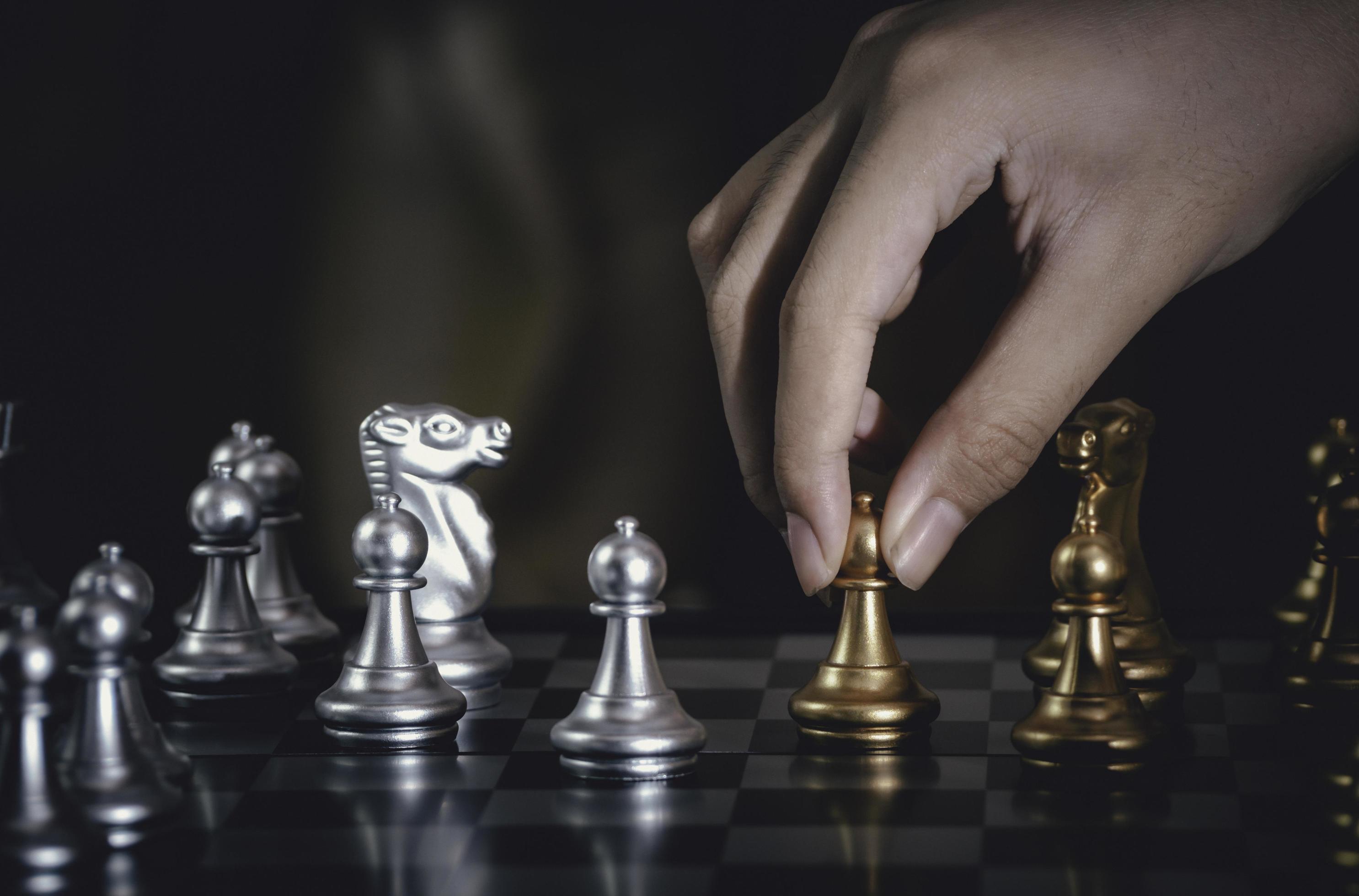 empresário de mão movendo xadrez de peão de prata lutando a bordo com fundo  de xadrez de ouro. com sucesso na competição com fundo de rede de  tecnologia. conceito de estratégia de