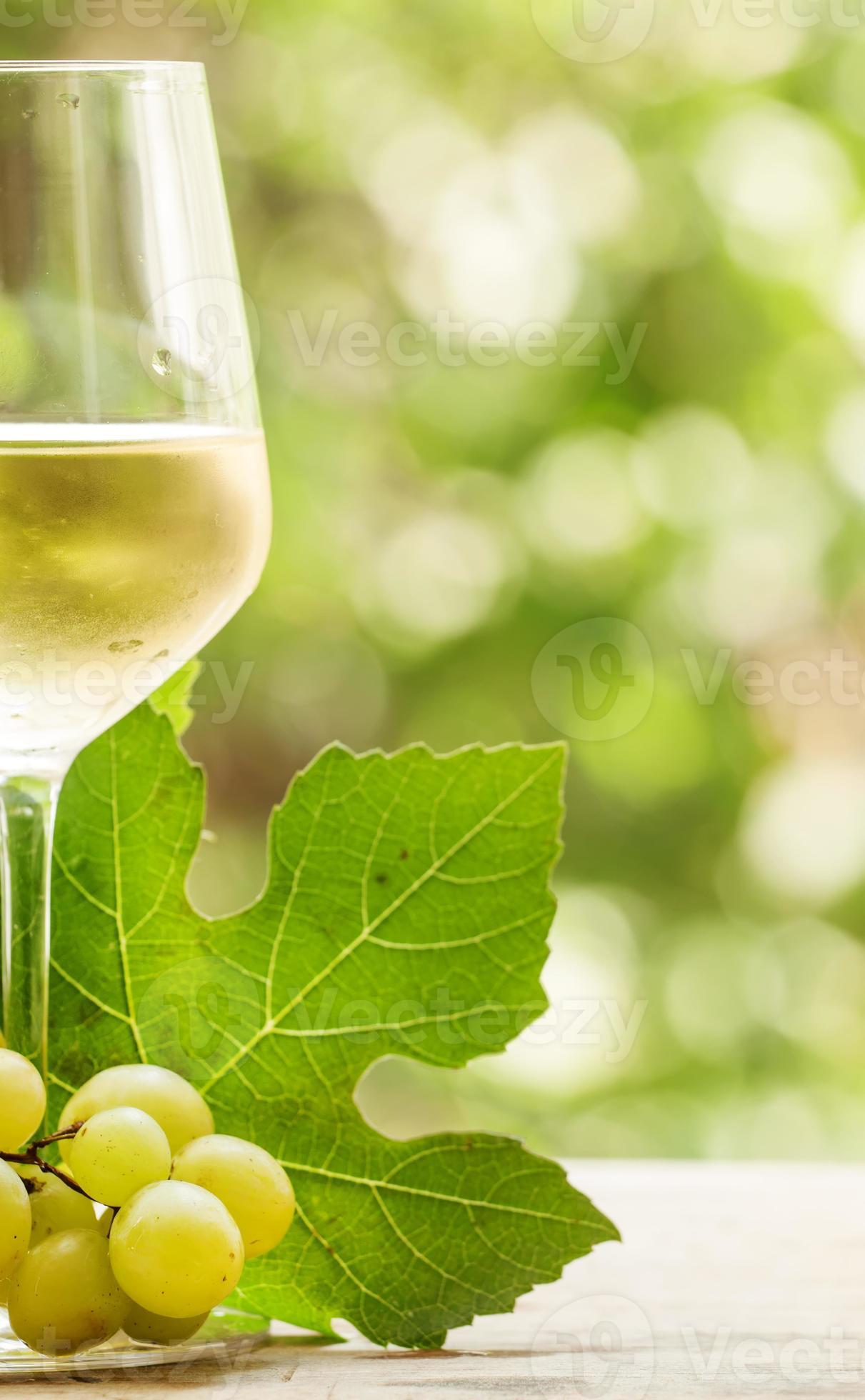 vinho branco e uvas verdes no fundo desfocado natural foto