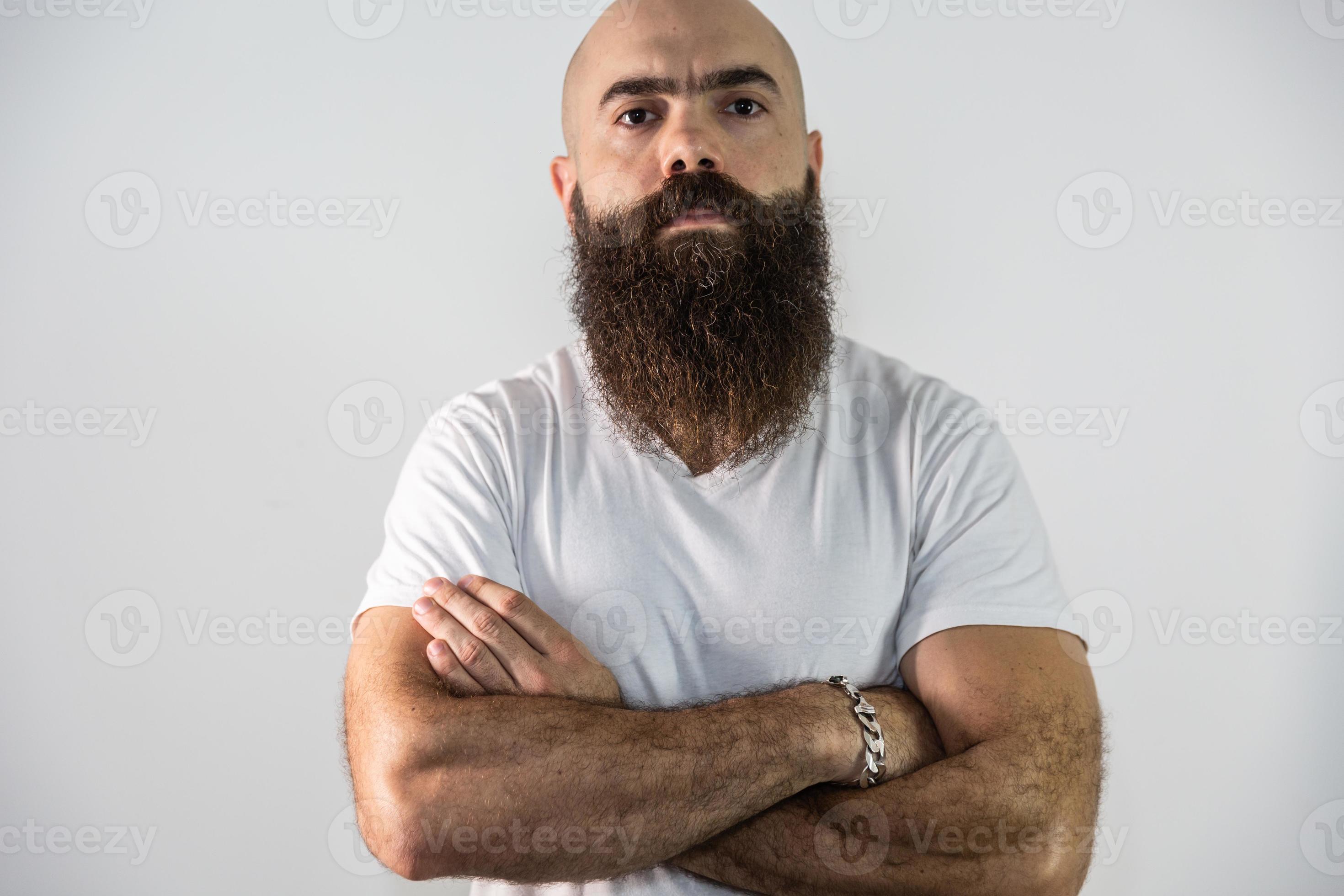 Retrato de homem barbudo bonito indeciso fazendo perguntas sobre o produto,  apontando o dedo para baixo inseguro, consultando a namorada, pergunte a  opinião, parede branca