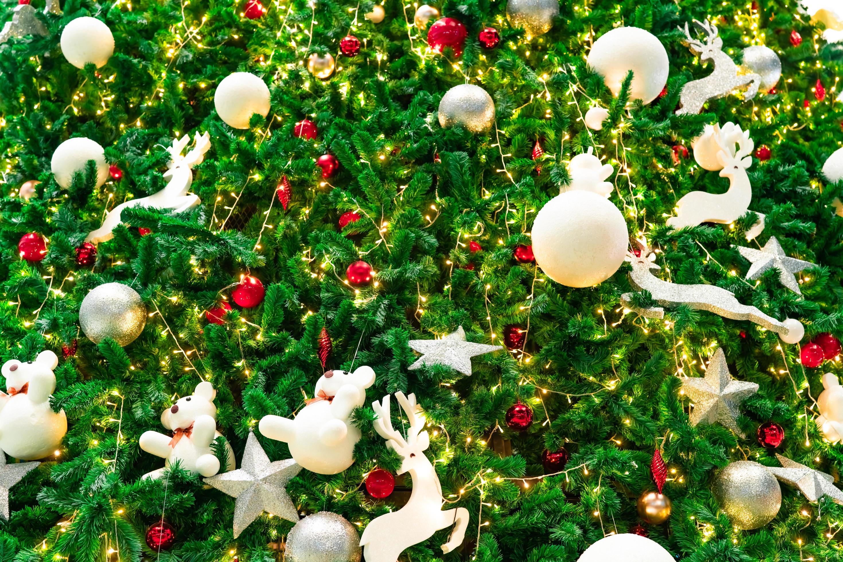 feche a decoração da árvore de natal com bolas vermelhas, douradas,  prateadas e brancas, estrela de prata e renas brancas. fundo de natal.  fundo de natal e feliz ano novo. bola colorida