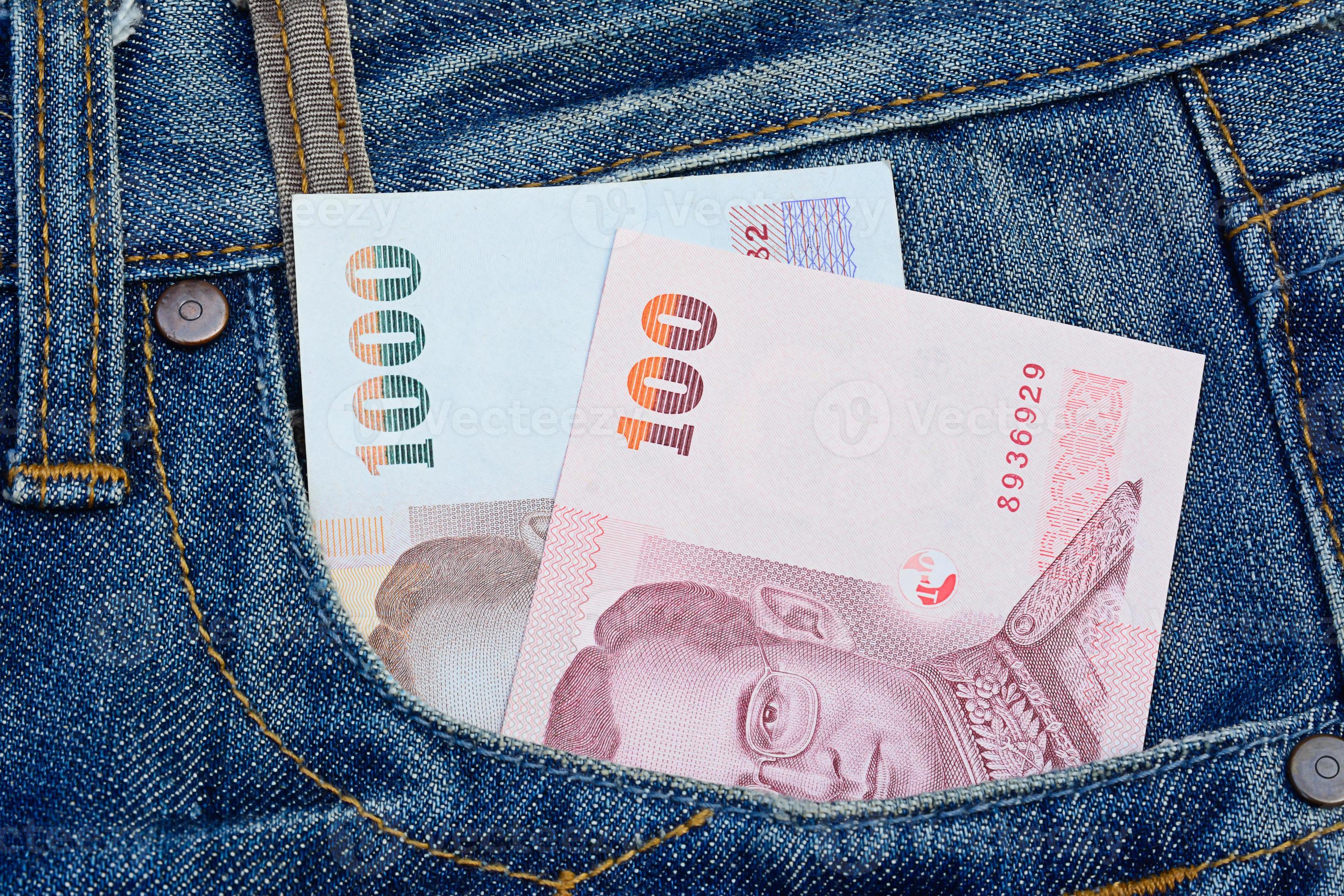 notas tailandesas no bolso da calça jeans por conceito de dinheiro e negócios foto