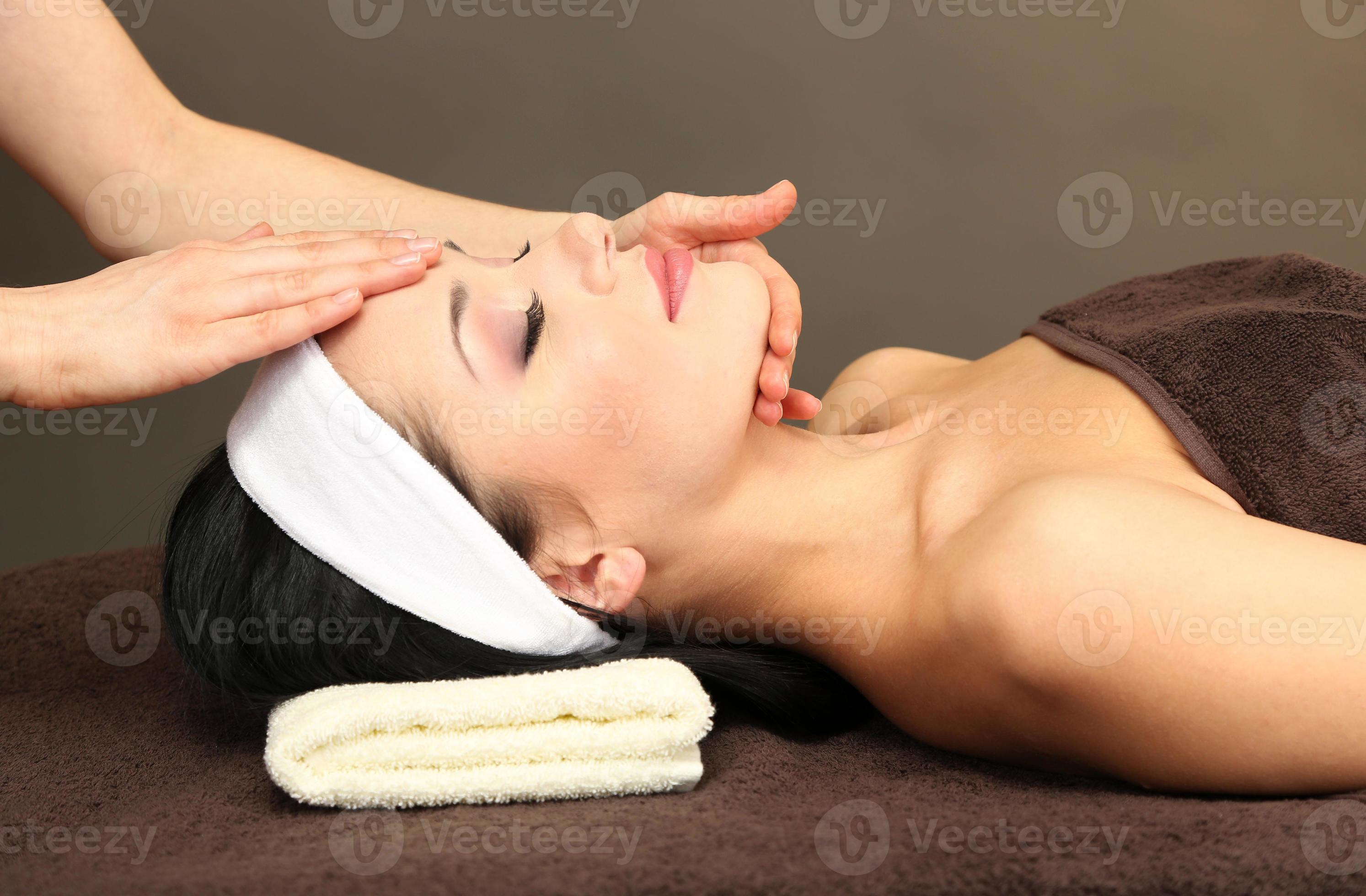 mulher jovem e bonita no salão spa, tendo a massagem na cabeça foto