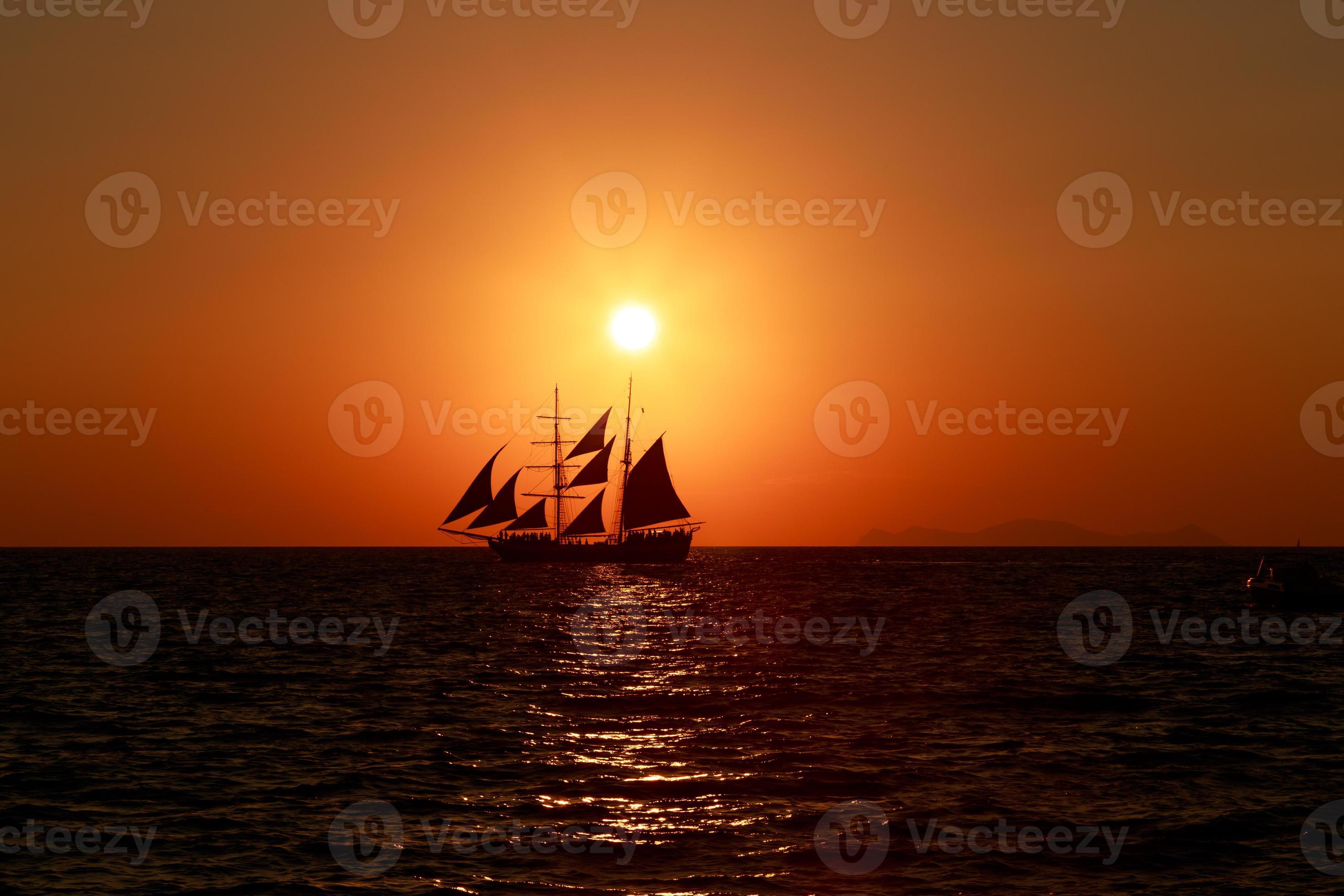 o pôr do sol sobre um veleiro em santorini. foto
