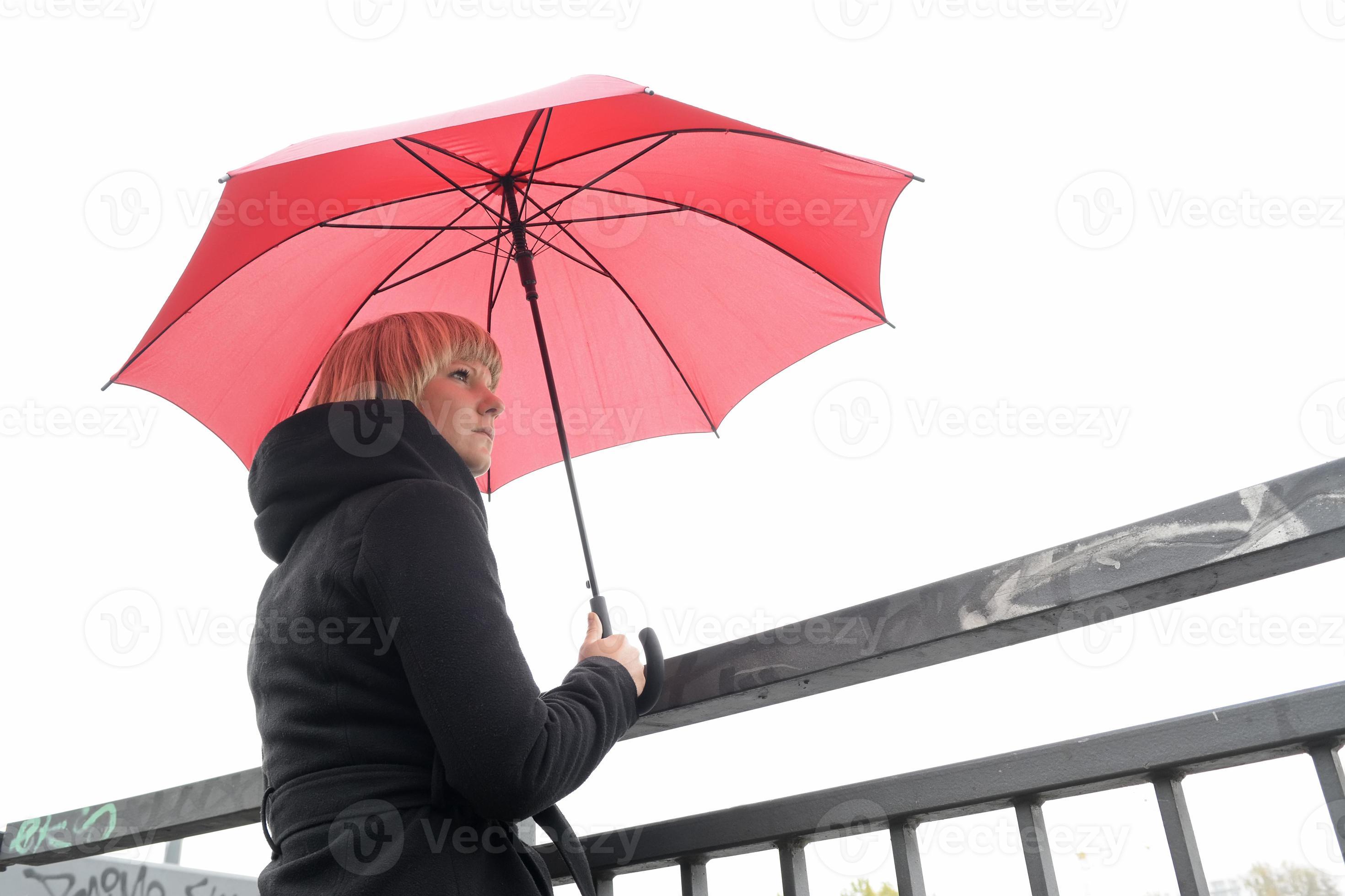 jovem mulher com pé de guarda-chuva vermelho nos trilhos, Berlim foto