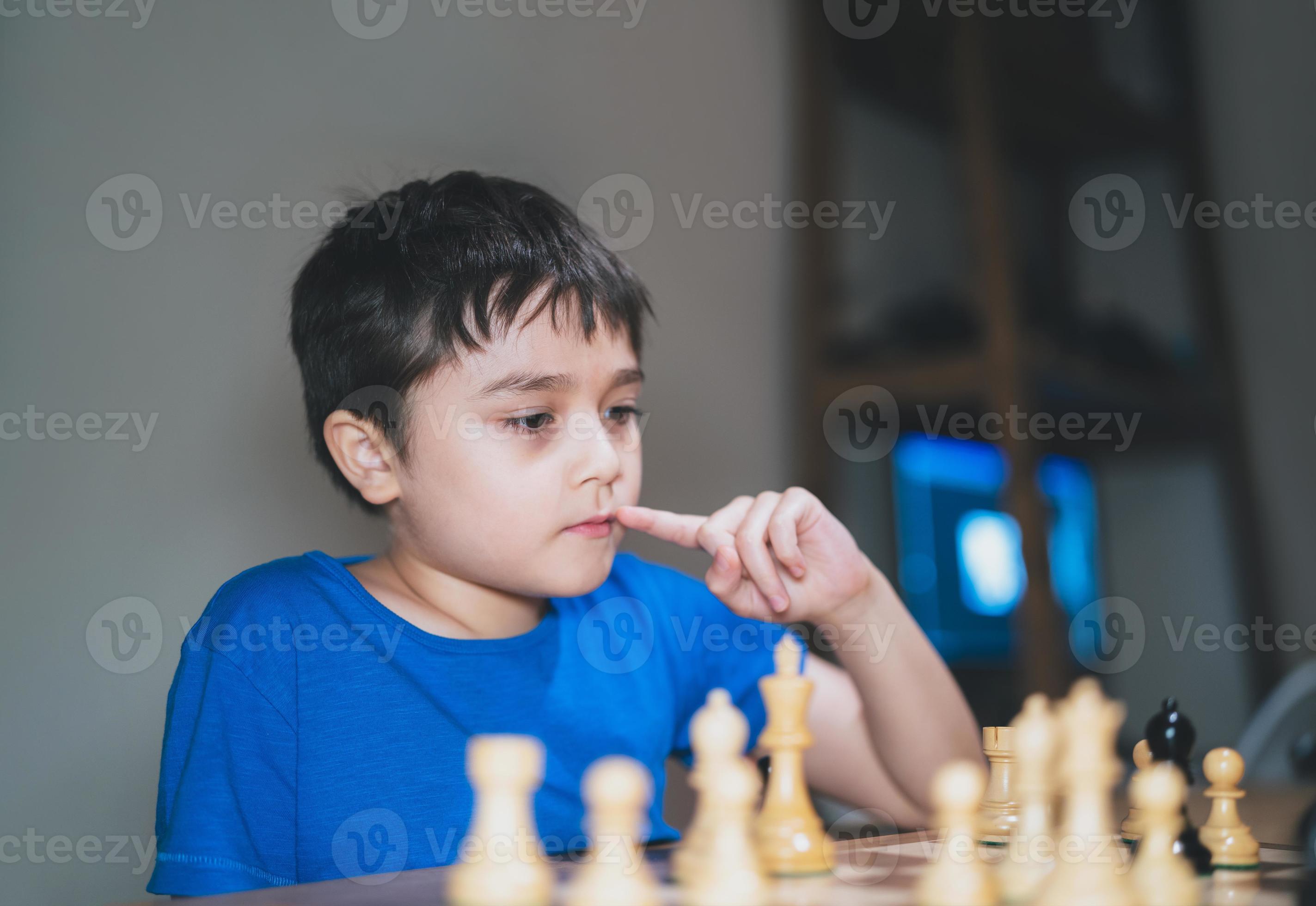 Um menino pré-escolar joga um jogo de tabuleiro de damas