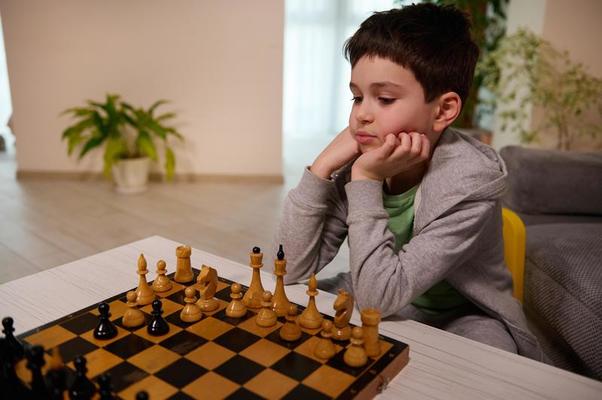 menino sério concentrado desenvolvendo gambito de xadrez, estratégia, jogando  jogo de tabuleiro para vencedor concentração inteligente e criança pensante  enquanto joga xadrez. conceito de aprendizagem, tática e análise. 7292830  Foto de stock