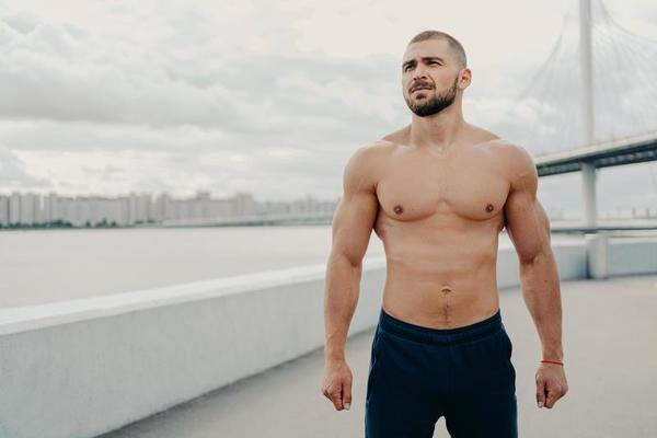 homem musculoso com torso nu durante treino de fitness em uma