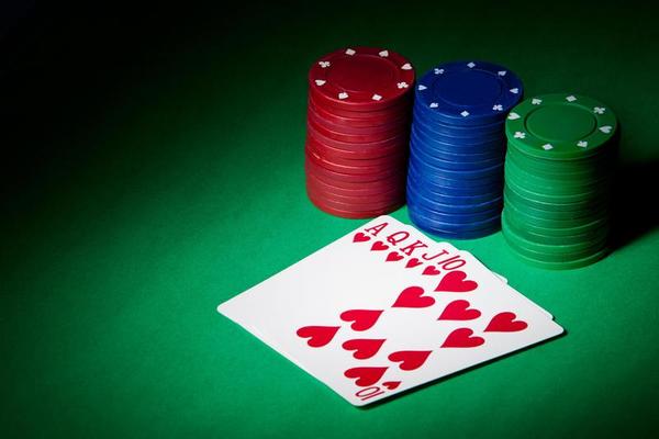 Royal flush baralho e fichas de casino em fundo verde poker