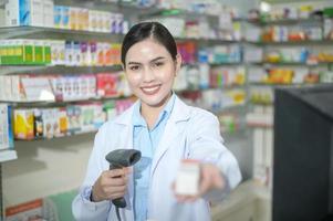 farmacêutico feminino escaneando código de barras em uma caixa de remédios em uma farmácia moderna. foto