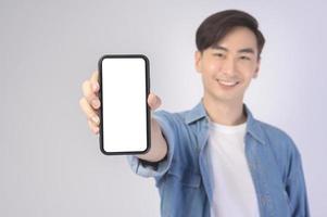 jovem asiático usando smartphone sobre fundo branco, conceito de tecnologia. foto